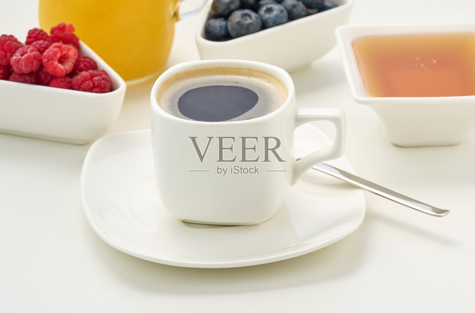 白色的桌子上放着白色的陶瓷杯和黑咖啡，早餐照片摄影图片