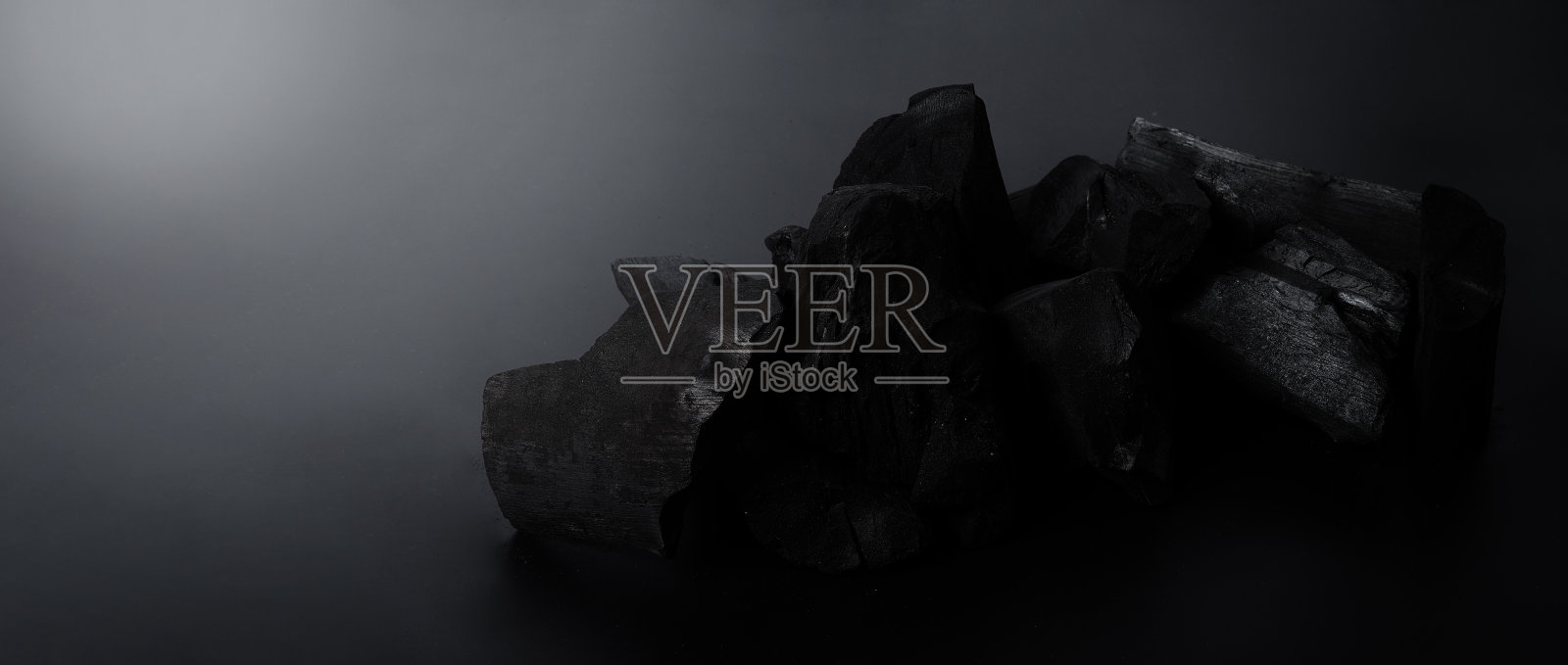 木炭。黑色纹理地板上的黑色木炭。用于烹饪、烧烤或其他行业。天然木炭。由木材强烈加热产生的炭黑残渣。对于传统的烧烤照片摄影图片