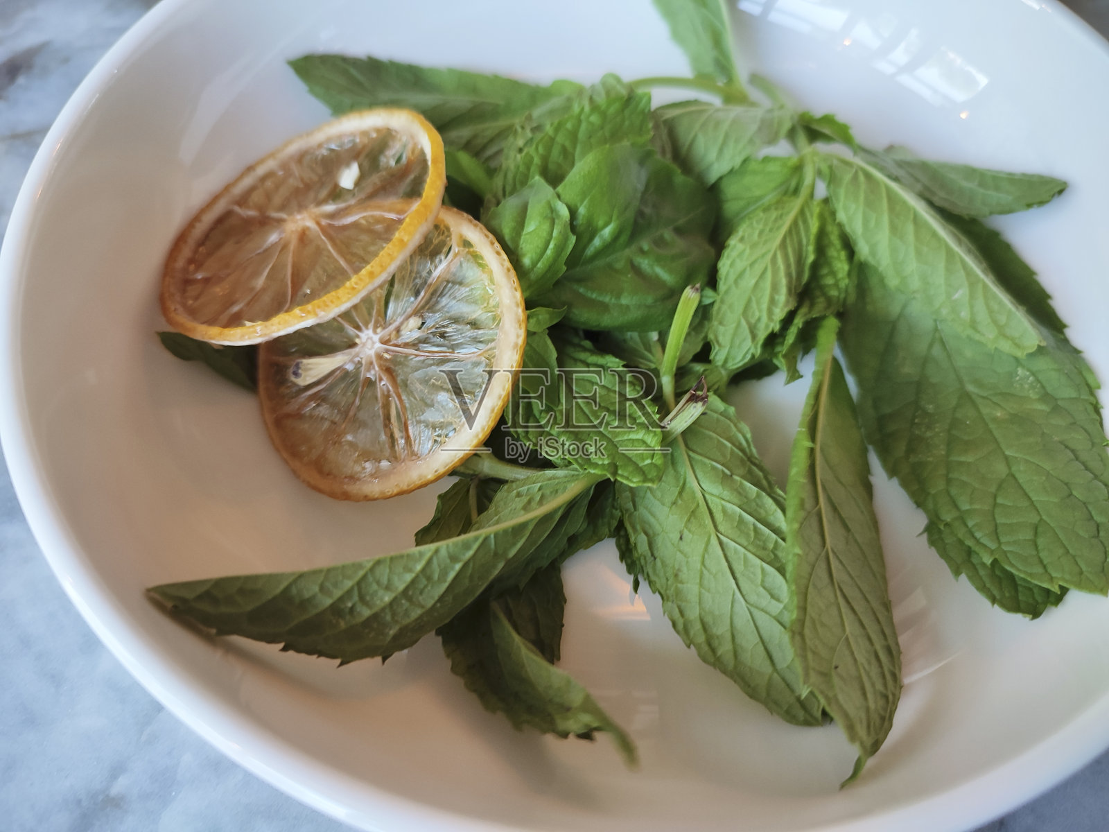 碗里放新鲜的薄荷叶。照片摄影图片