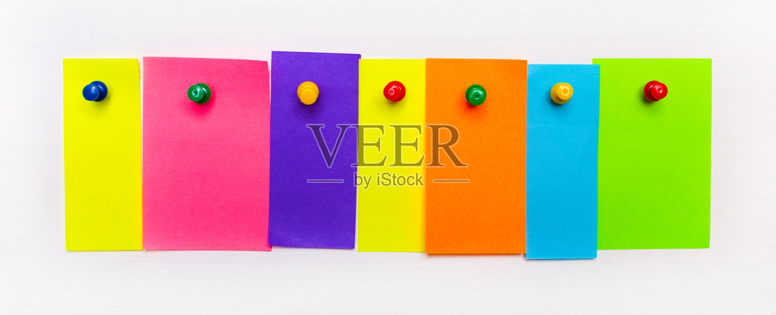 在白色的背景上，明亮的多色纸条上有一个地方可以插入文本，用按钮固定。模板照片摄影图片