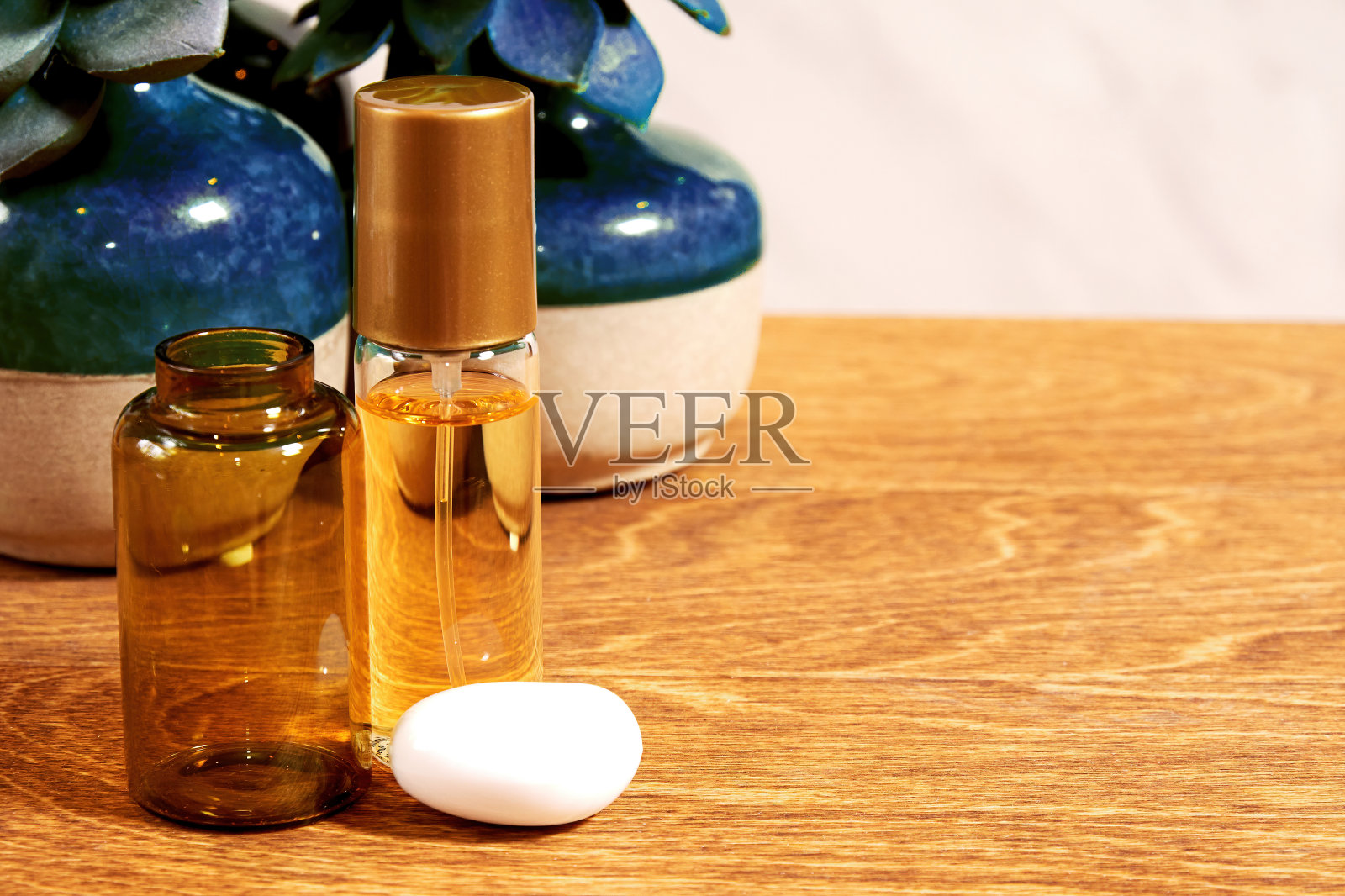 时尚店化妆台配有金色香水瓶和装饰植物。化妆品背景与复制空间广告文本照片摄影图片