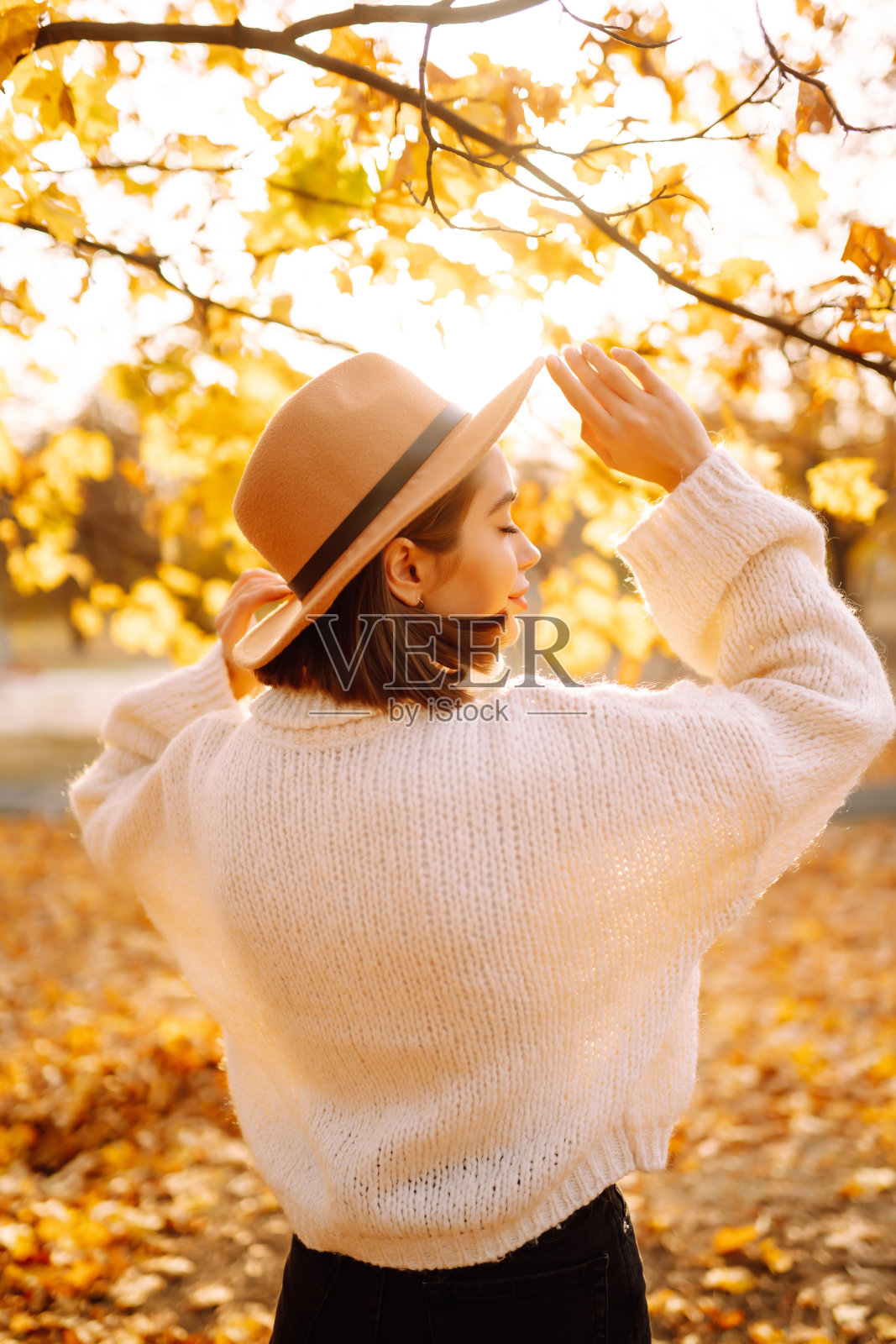 阳光生活肖像年轻时尚的女人走在公园，戴着可爱的时髦的帽子。照片摄影图片