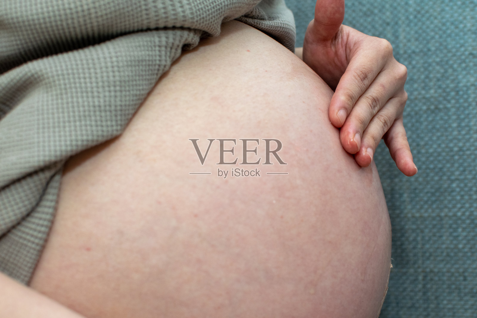 一名年轻的亚洲孕妇使用润肤露以避免造成妊娠纹照片摄影图片