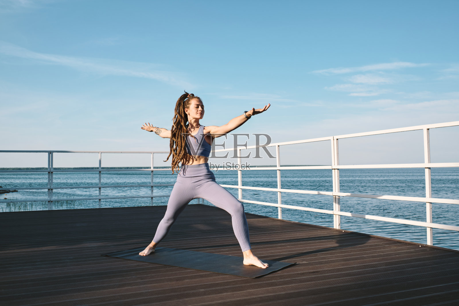 年轻的赤脚女人站在垫子上瑜伽练习照片摄影图片
