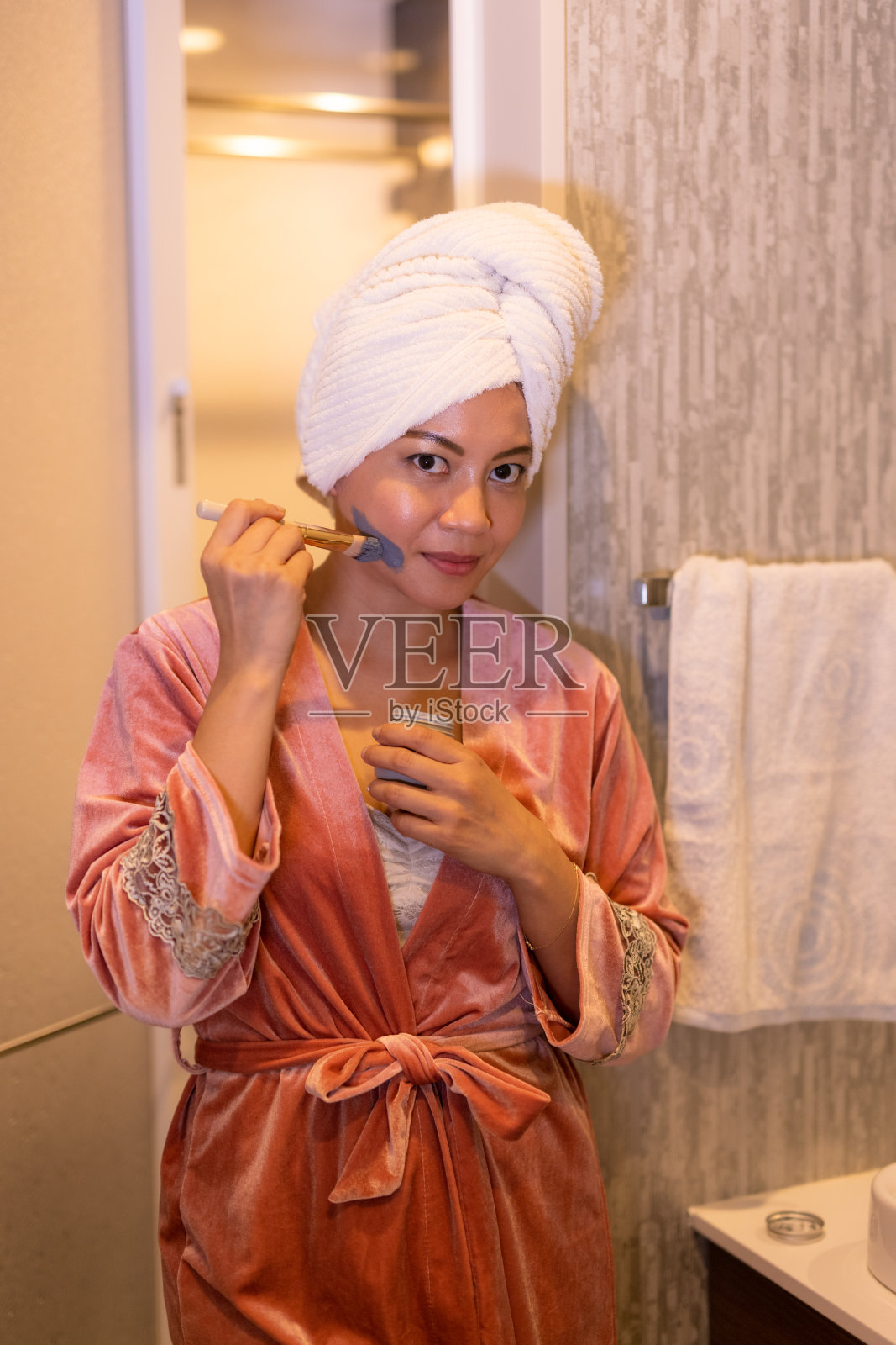 亚洲女人在浴室里擦面霜照片摄影图片