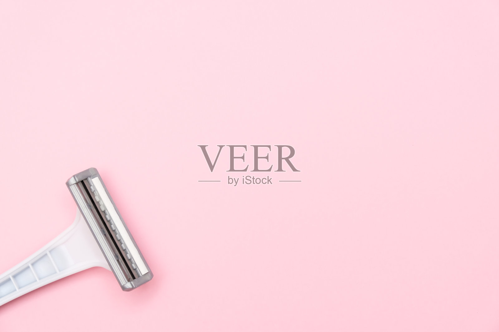 灰色女性塑料一次性剃刀刀片粉红色背景与复制空间照片摄影图片