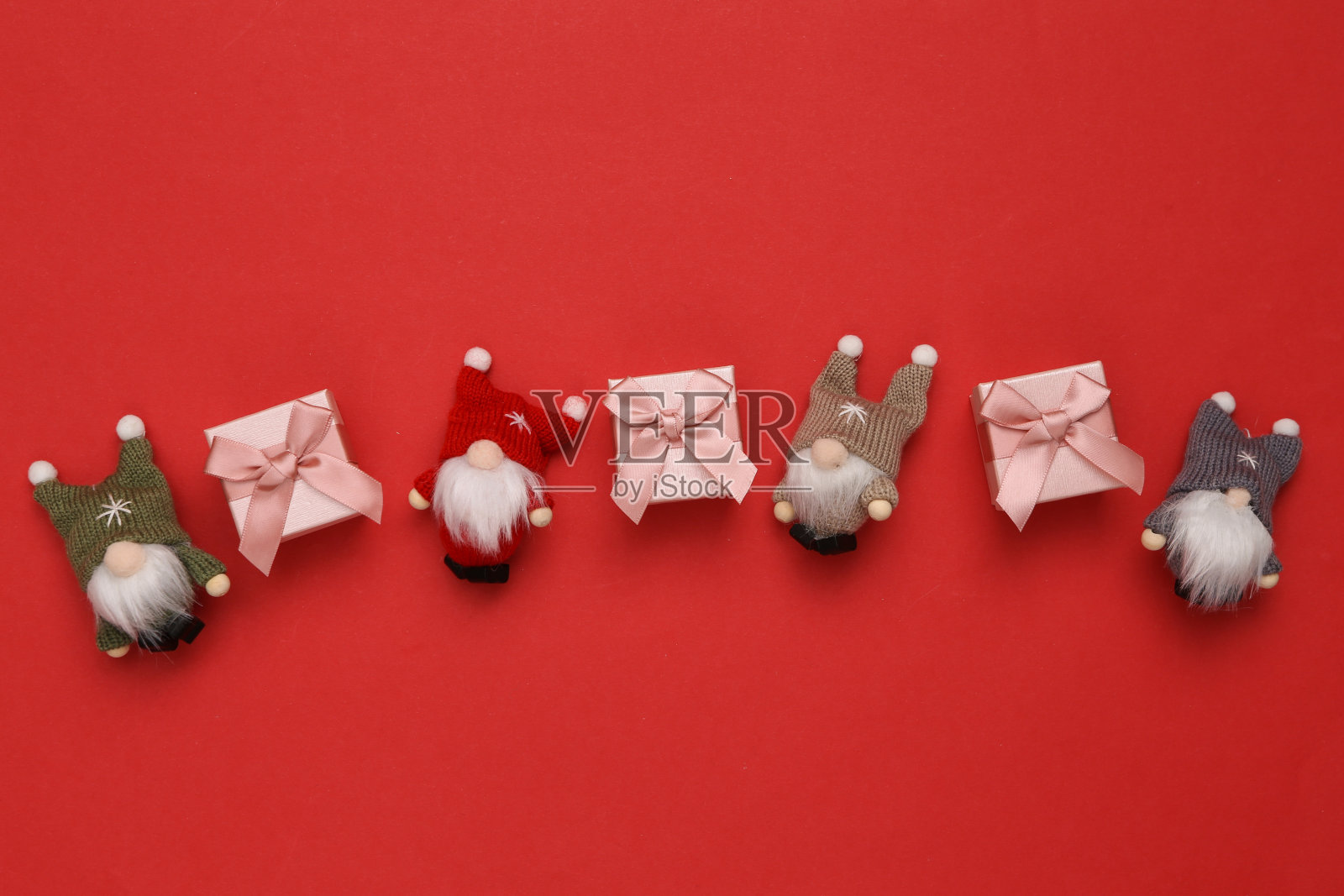 圣诞组成。圣诞精灵和红色背景的礼品盒照片摄影图片