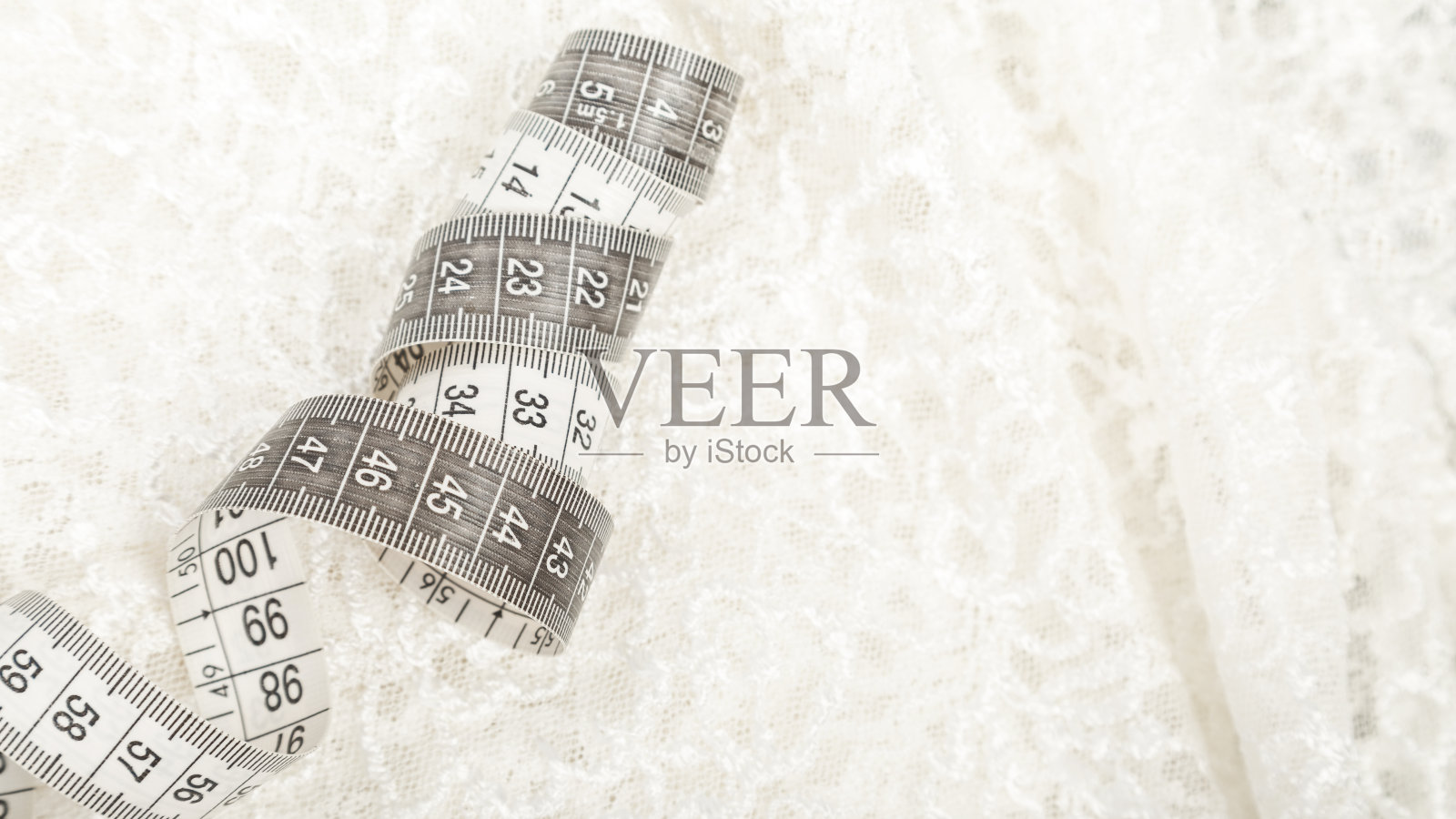 裁剪的概念。缝纫和针线活用的配件。白色刺绣织物和卷尺。背景照片摄影图片