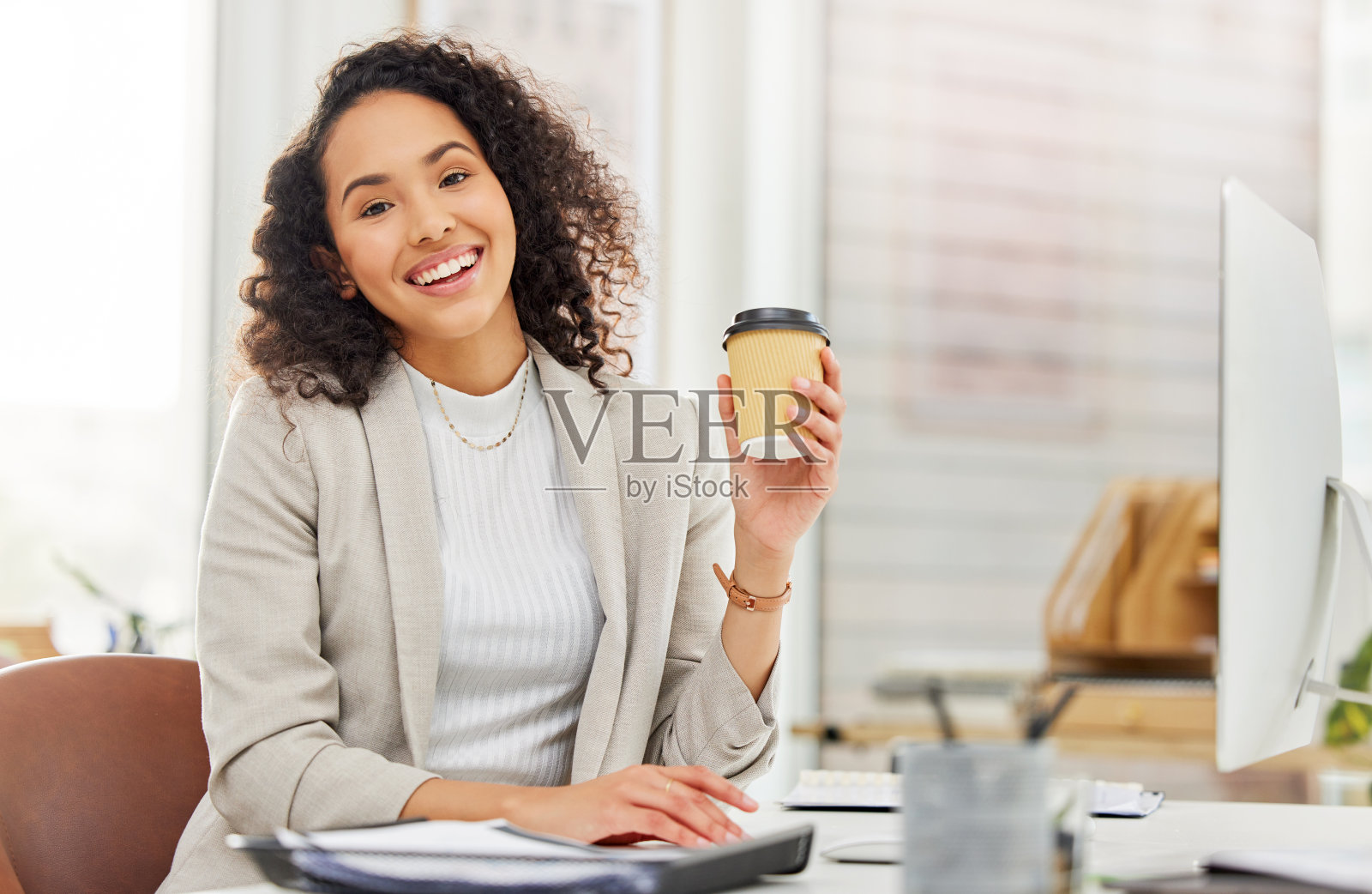 一个年轻的女商人在办公室里喝咖啡照片摄影图片