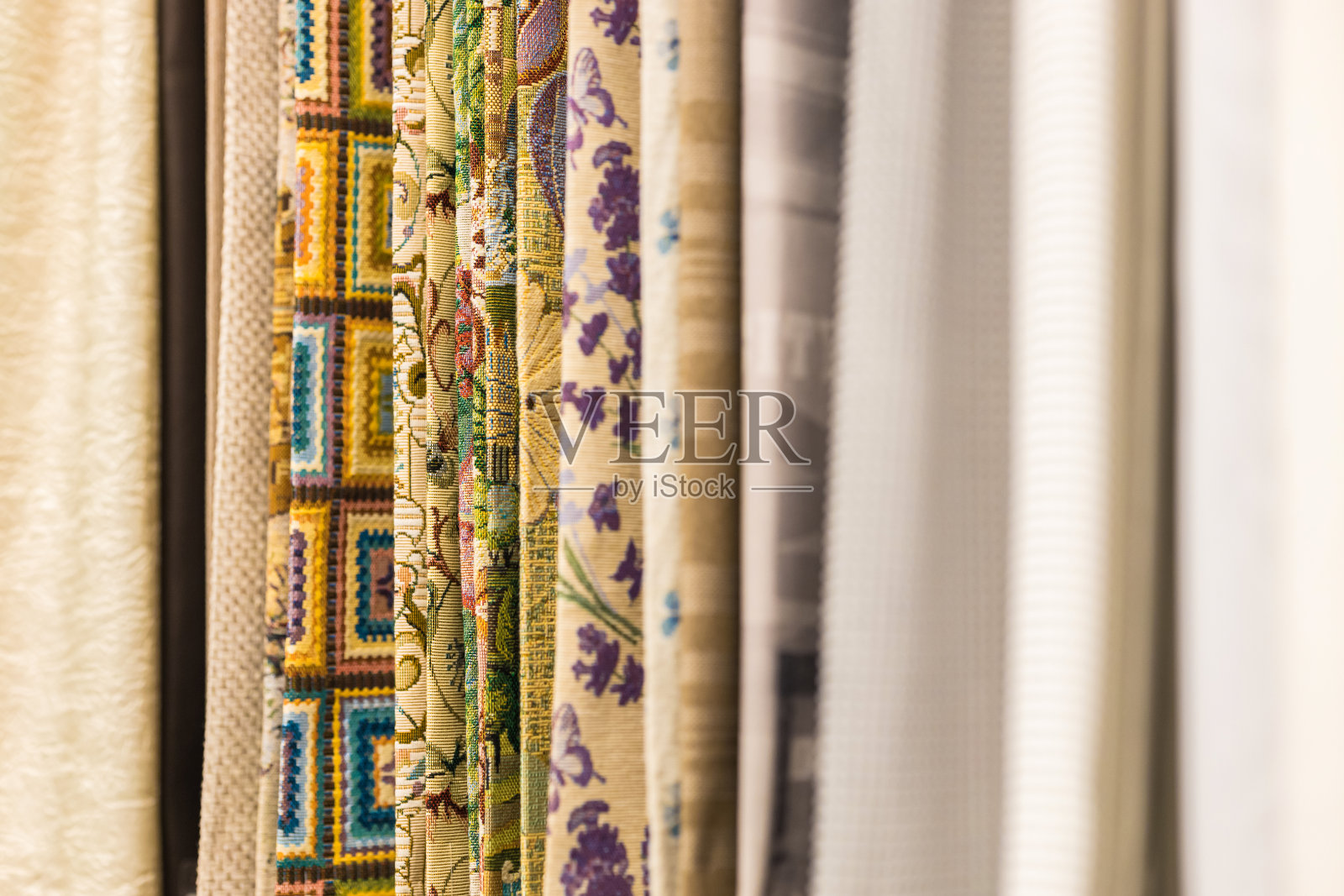 商店里各种彩色窗帘的模糊样品以零售的方式出售。照片摄影图片