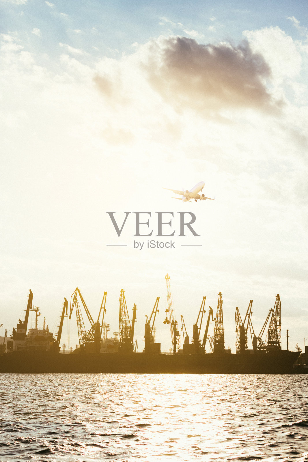 集装箱货轮和货机的物流运输与工作吊桥在港口的黄昏天空照片摄影图片