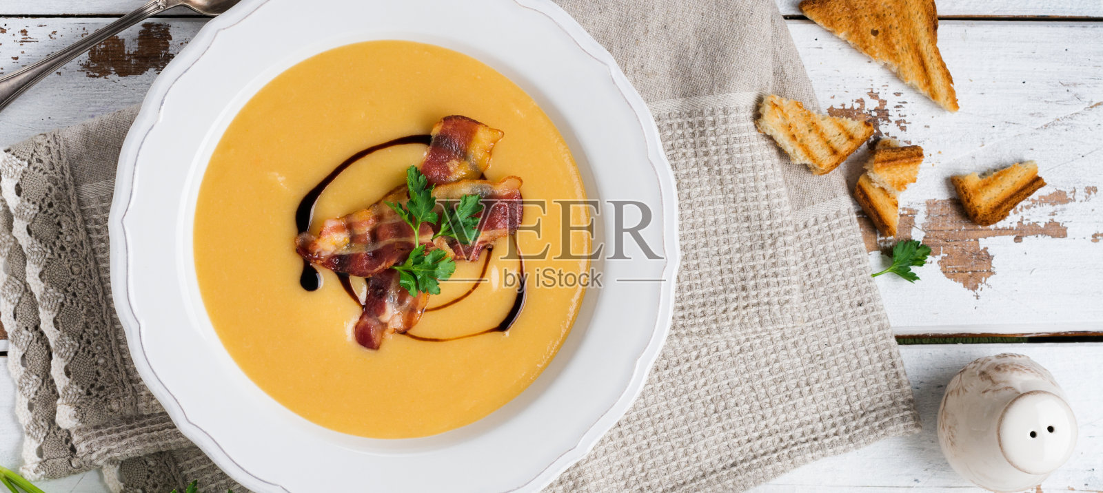 土豆汤奶油与培根和酱油在白色的碗，在浅色的旧木制背景。俯视图照片摄影图片