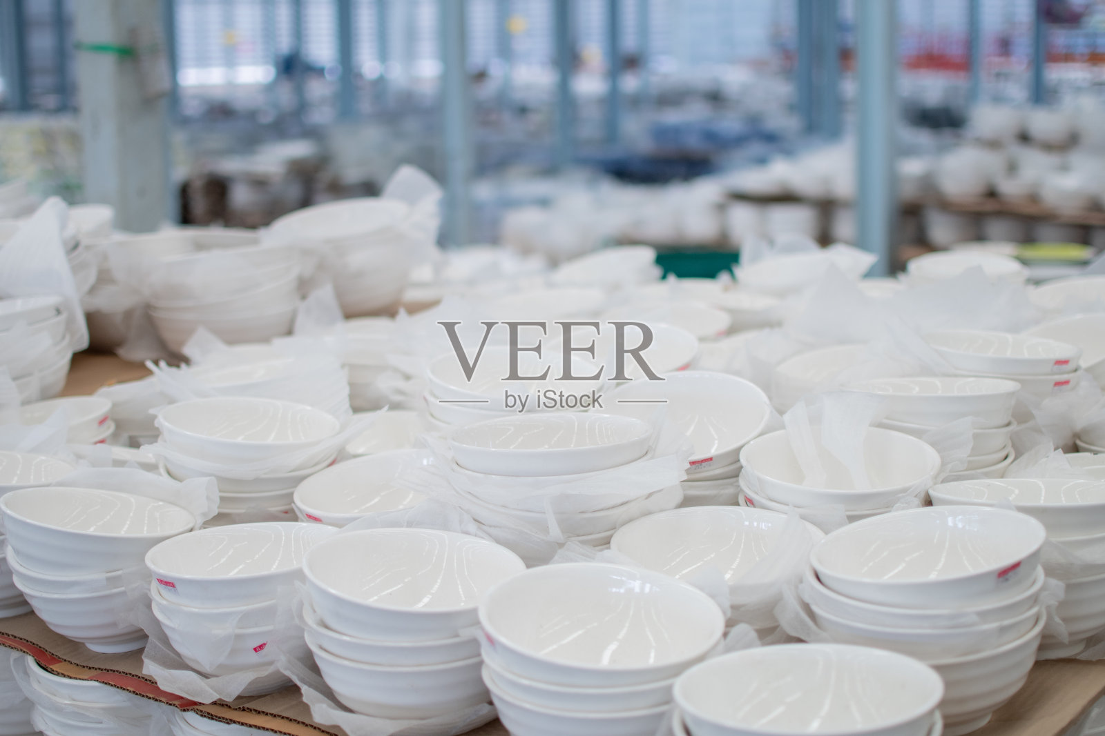 在批发商店里，女人的手拿着一堆陶瓷盘子照片摄影图片