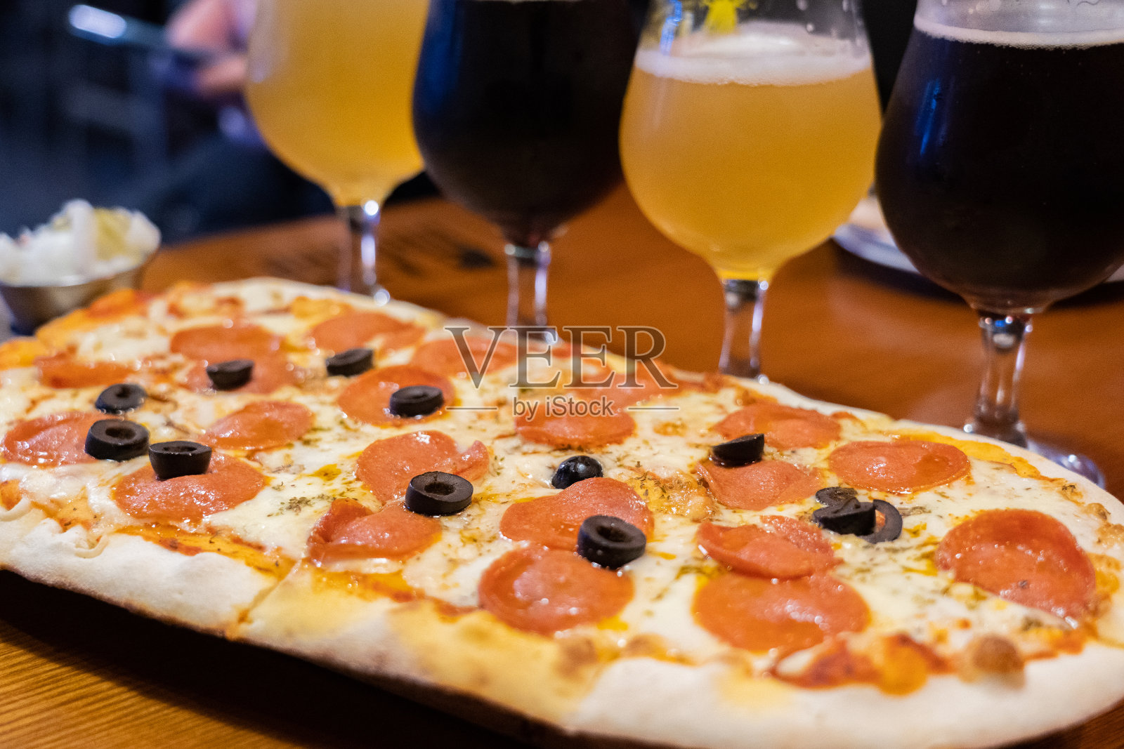 两杯啤酒和披萨，黄色背景照片摄影图片