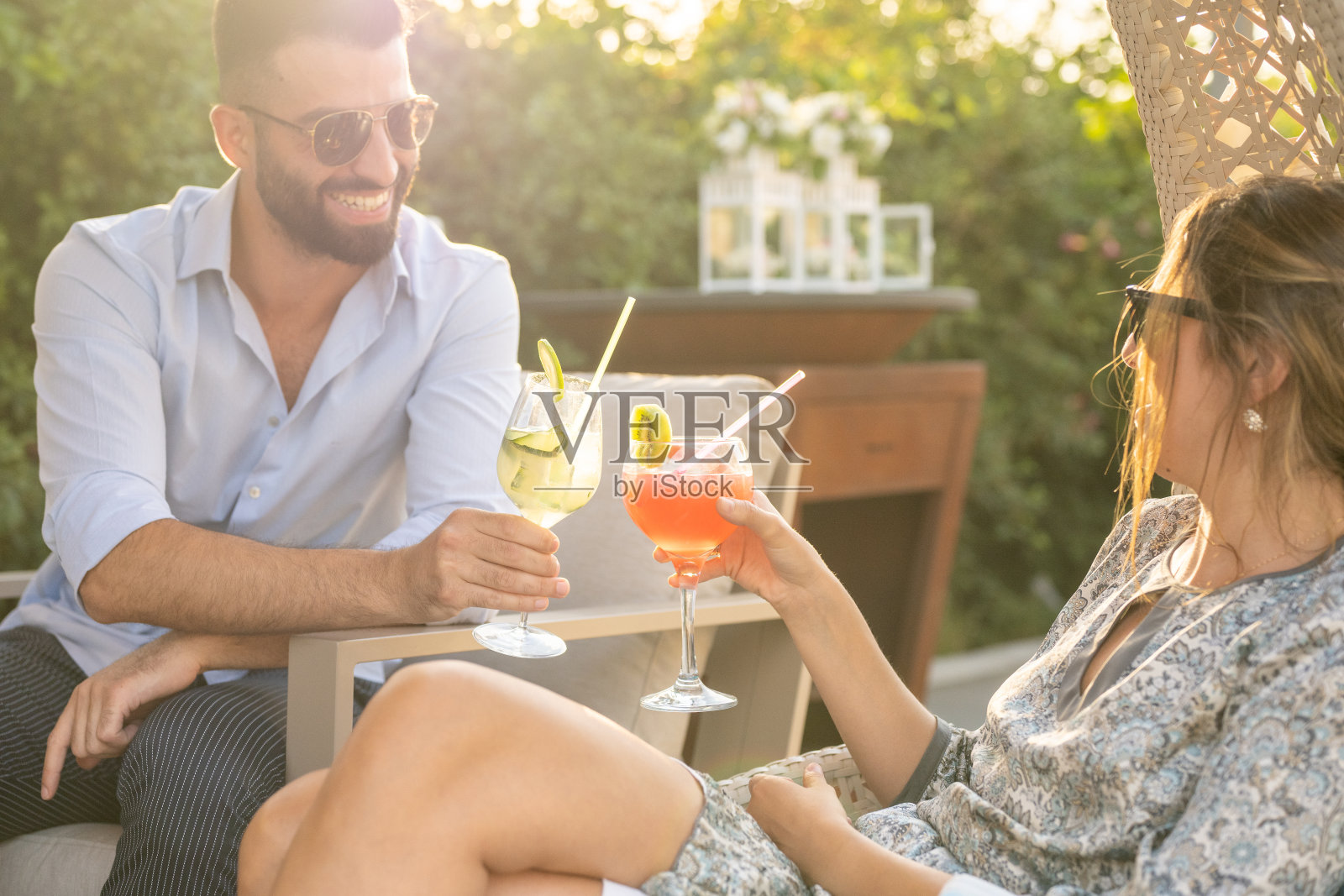 迷人的年轻男子与一个英俊微笑的女人一起举杯，幸福和乐趣的时刻，一对情侣的第一次约会，靠近玻璃杯照片摄影图片