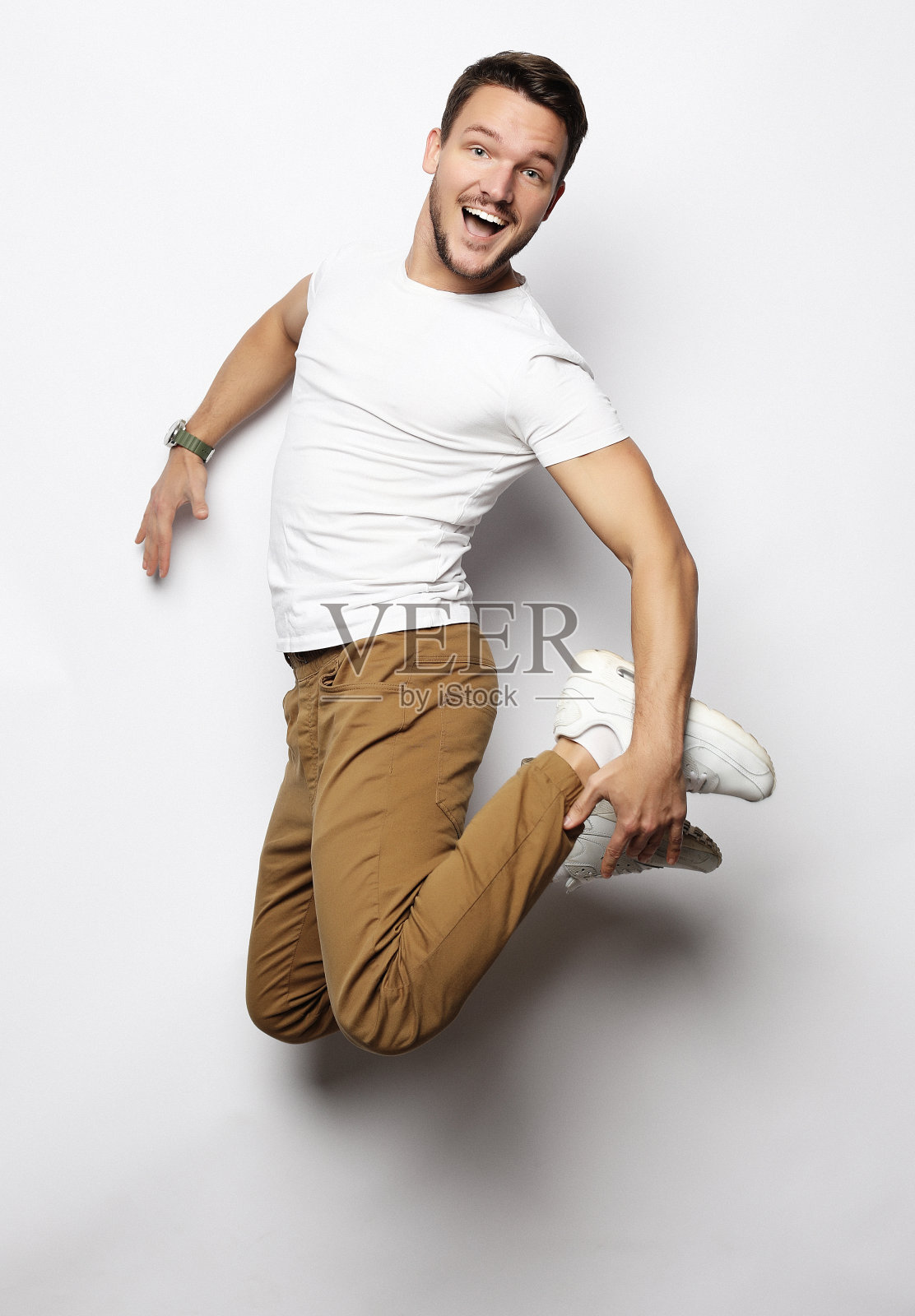 微笑快乐的男人在白色的背景上跳跃照片摄影图片