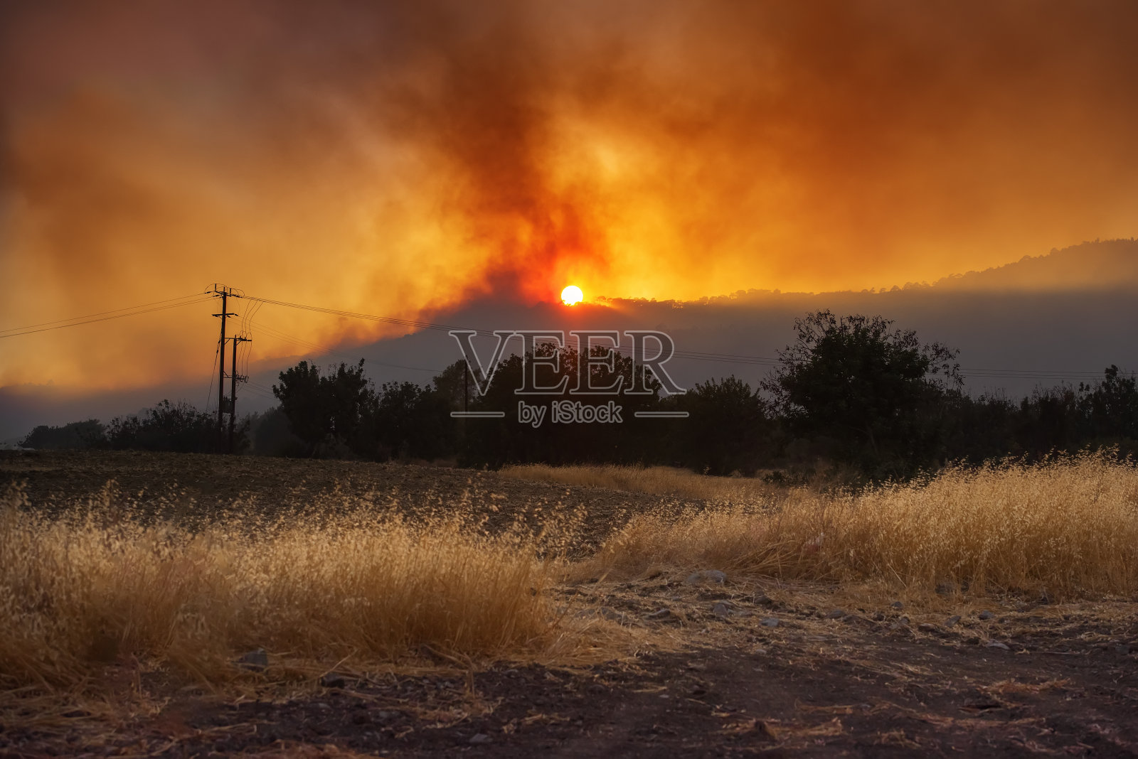 夕阳西下的乡村风景与农田和戏剧性的野火照片摄影图片