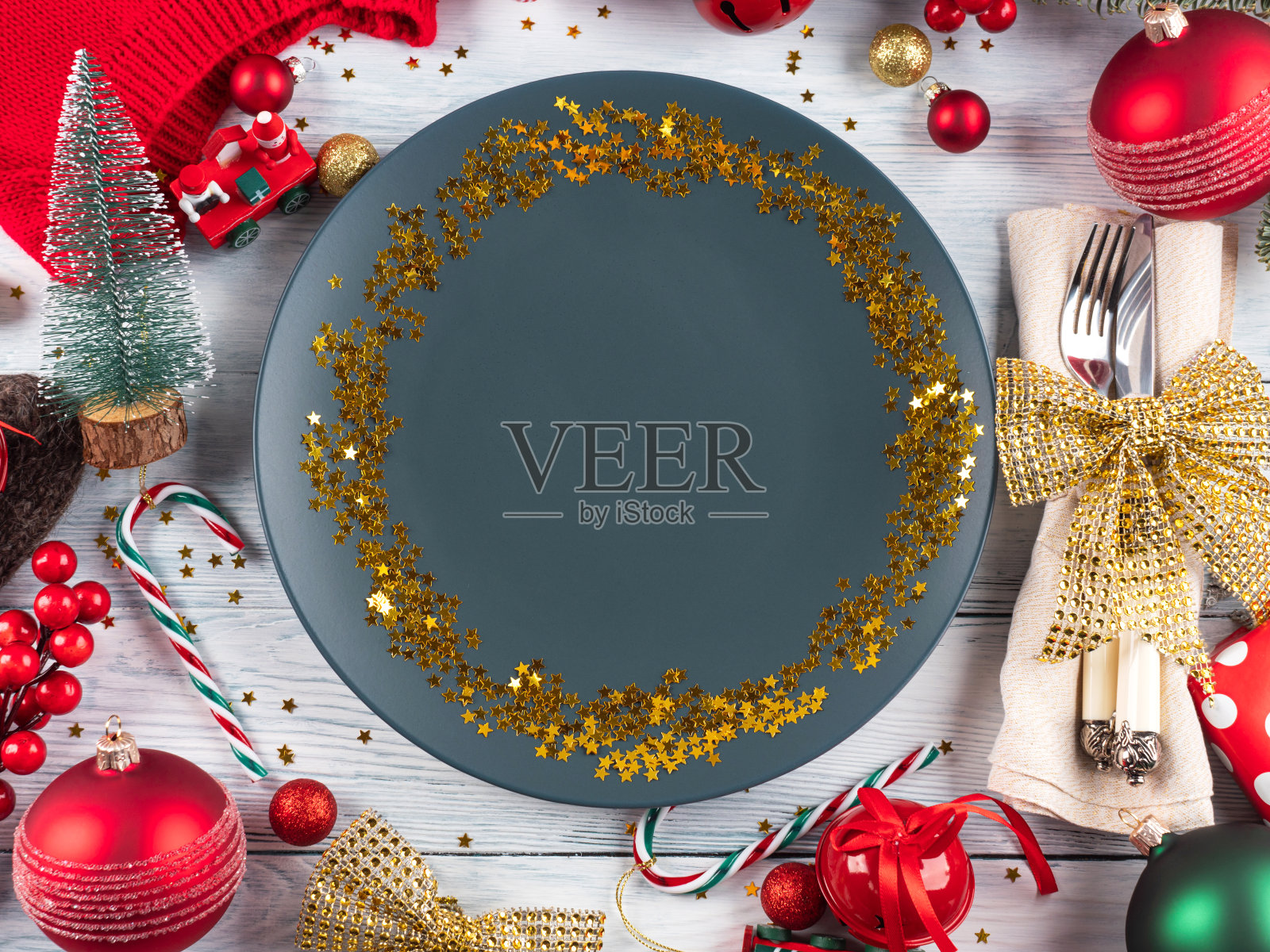 圣诞节的餐桌布置与蓝色的空盘子与金色的星星纸屑和装饰照片摄影图片