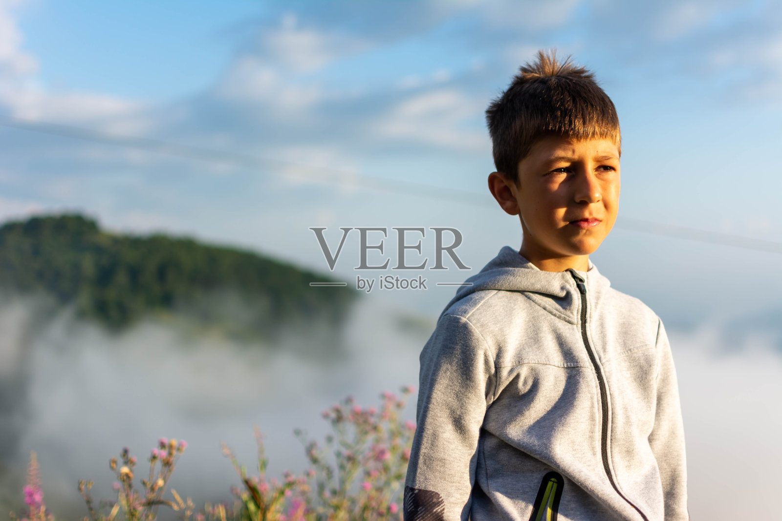 快乐的童子男孩在温暖晴朗的夏日与云彩在户外。照片摄影图片