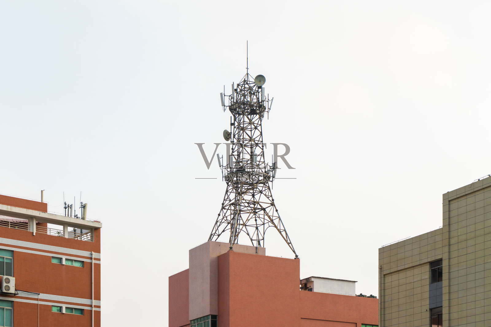 5g信号塔位于城市居民楼顶部照片摄影图片