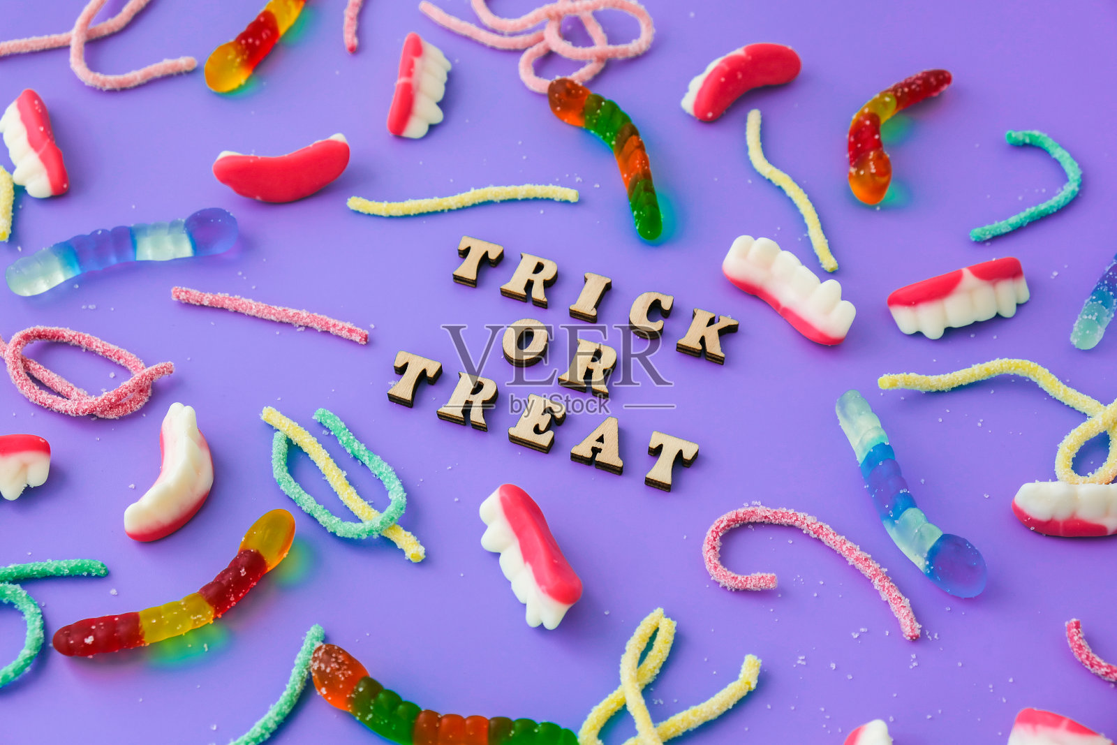 万圣节的概念。万圣节派对装饰与文字TRICK OR TREAT，糖果，俯视图平躺在蓝色背景照片摄影图片