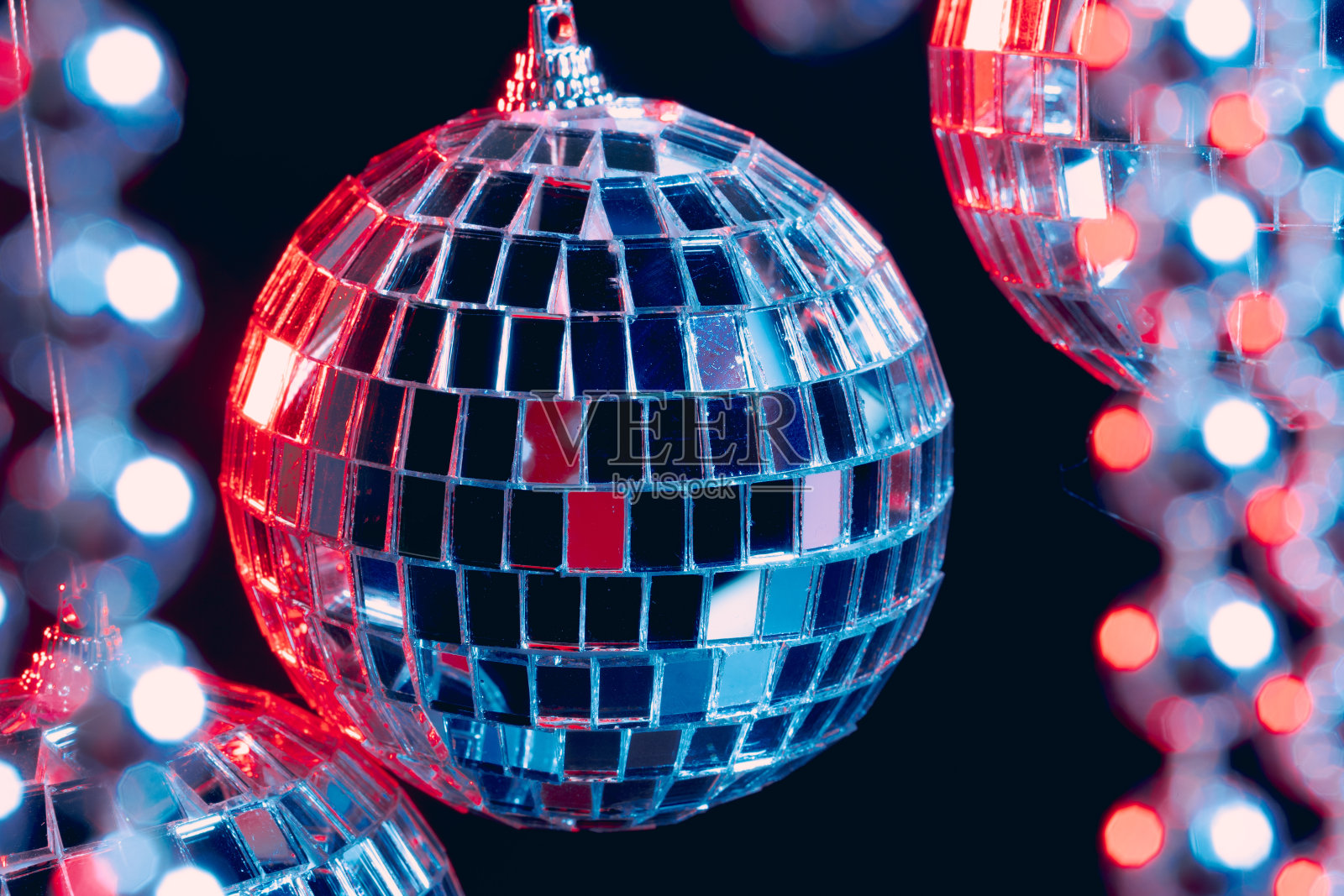 闪亮的迪斯科球悬挂在空中，衬托着黑色的背景照片摄影图片