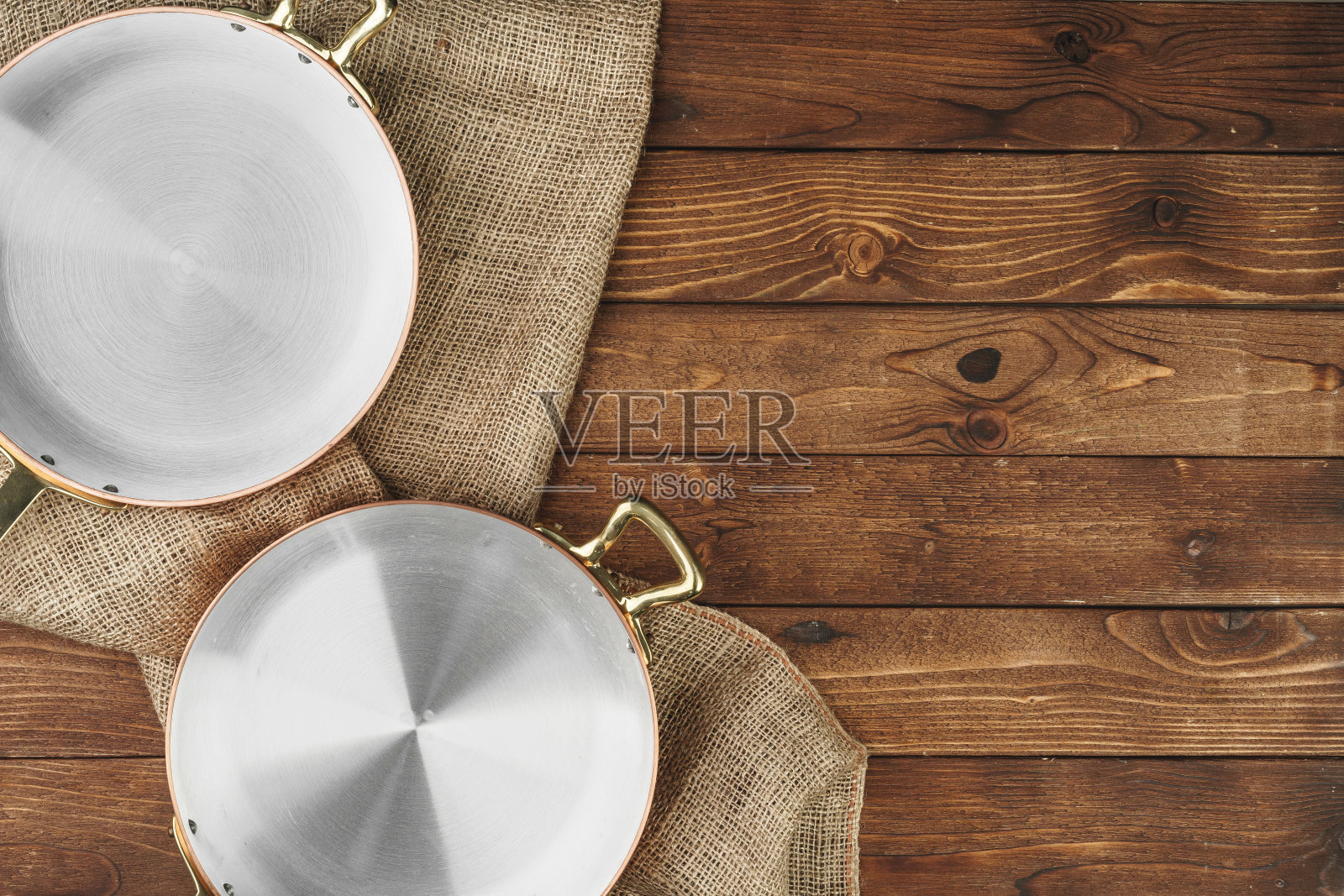木制背景上的铜煎锅，俯视图照片摄影图片