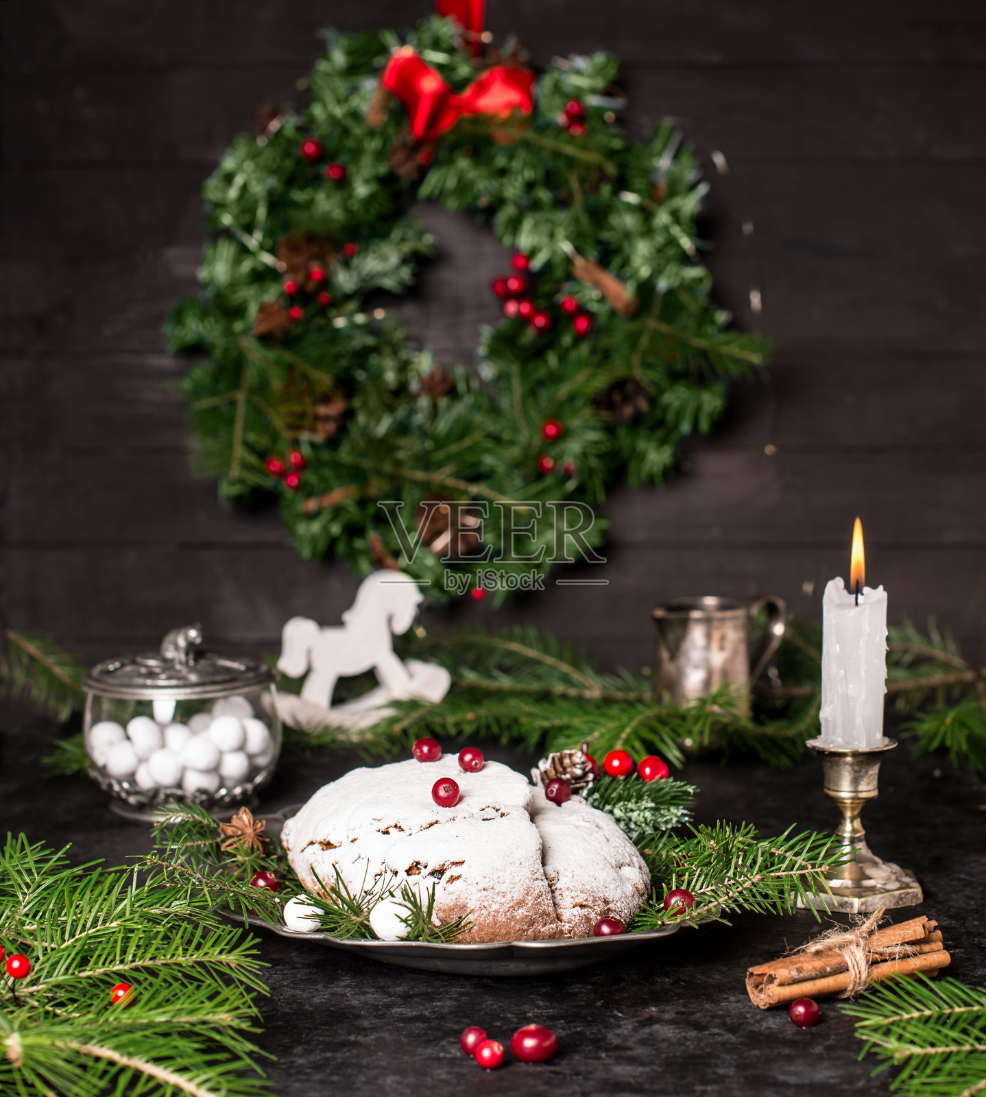 传统的圣诞水果蛋糕在黑色木制乡村背景与圣诞装饰。照片摄影图片