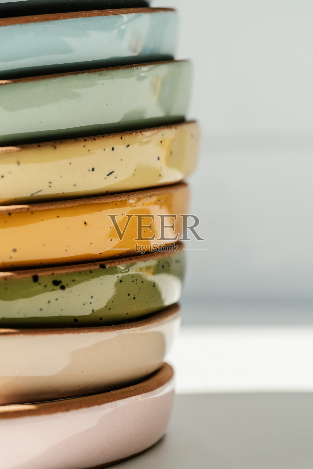 一大堆颜色柔和的陶瓷杯。照片摄影图片