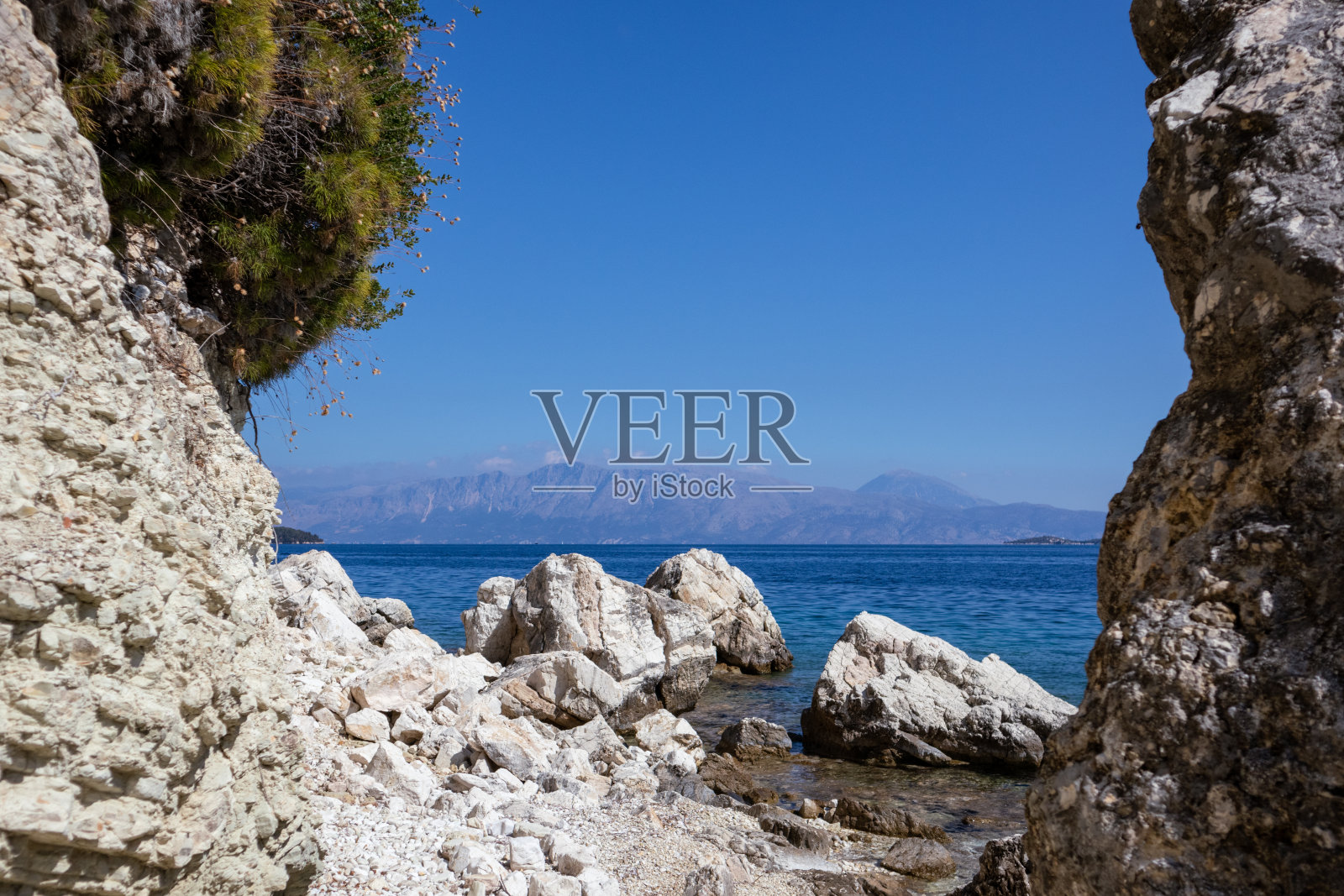 希腊，白色的石头和绿意盎然的沙滩照片摄影图片