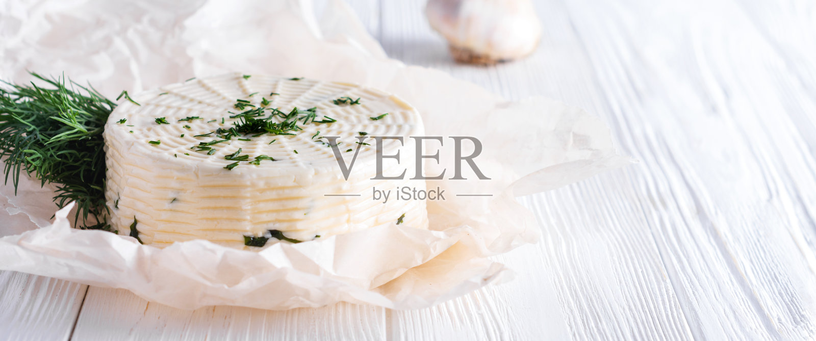 腌奶酪配小茴香，香料和大蒜，白色木制背景。有选择性的重点照片摄影图片