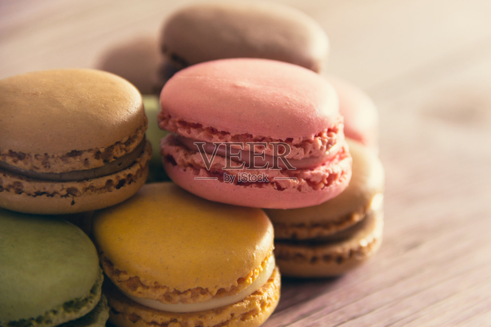法式马卡龙的甜点，颜色柔和，放在木头上。副本的空间。有选择性的重点。照片摄影图片