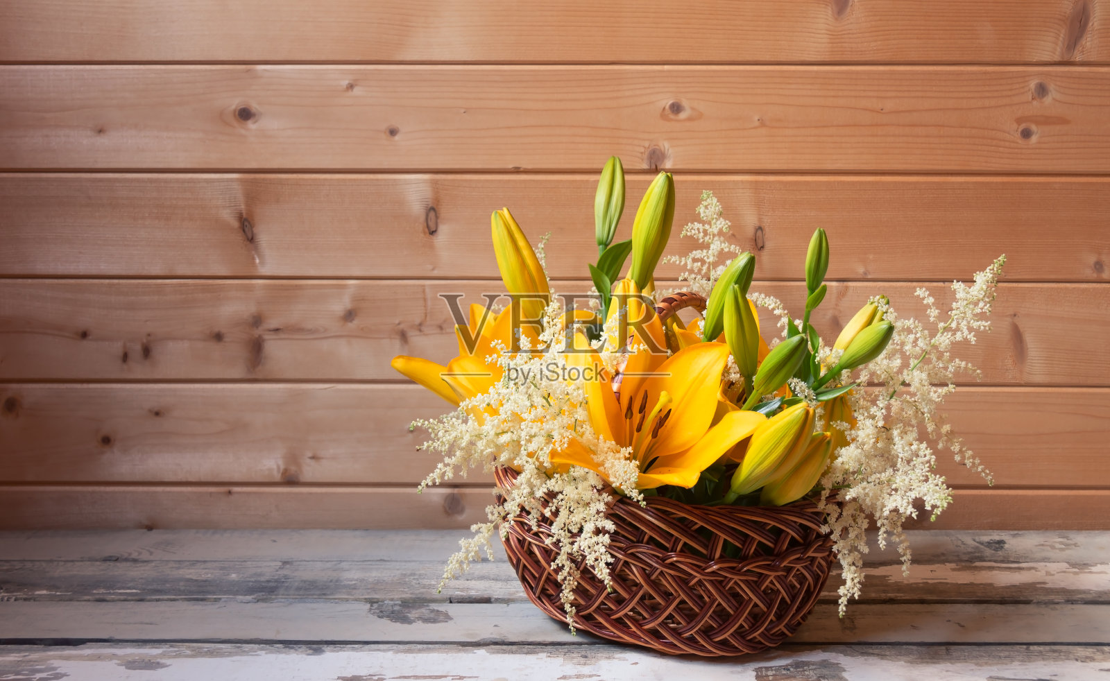 一束美丽的黄色百合和白色落新妇花放在旧木桌上。照片摄影图片
