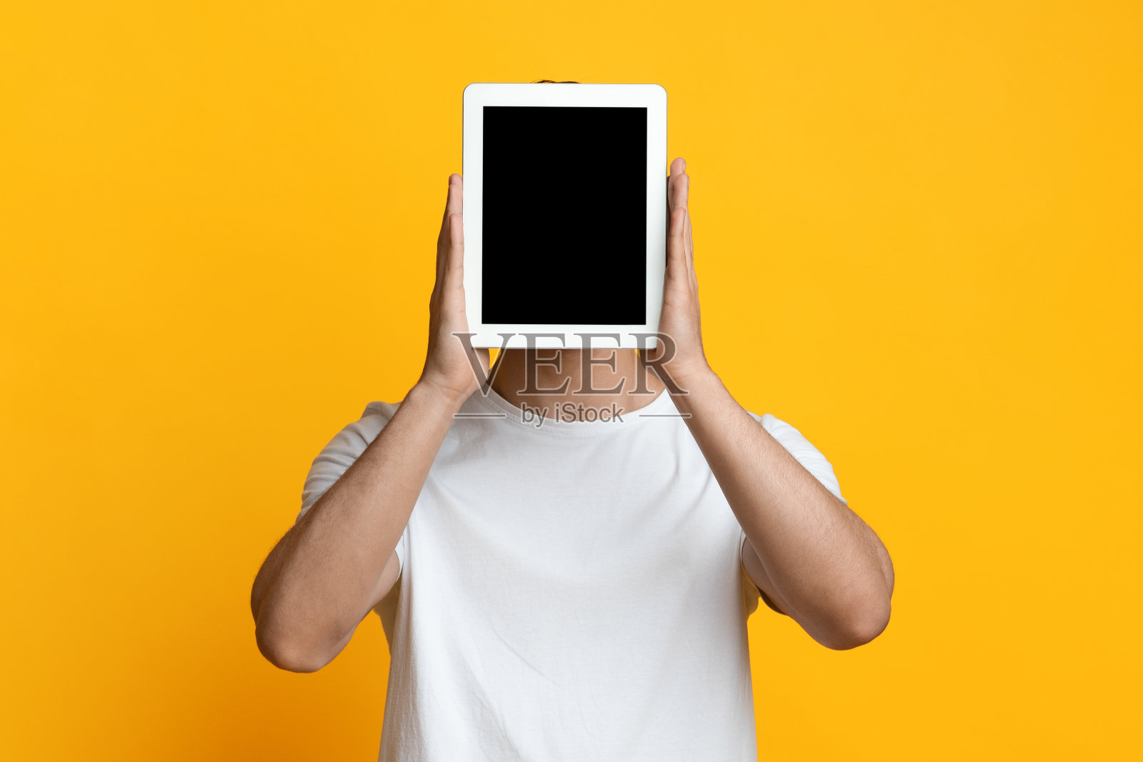 男子躲在带空白屏幕的平板电脑后面照片摄影图片