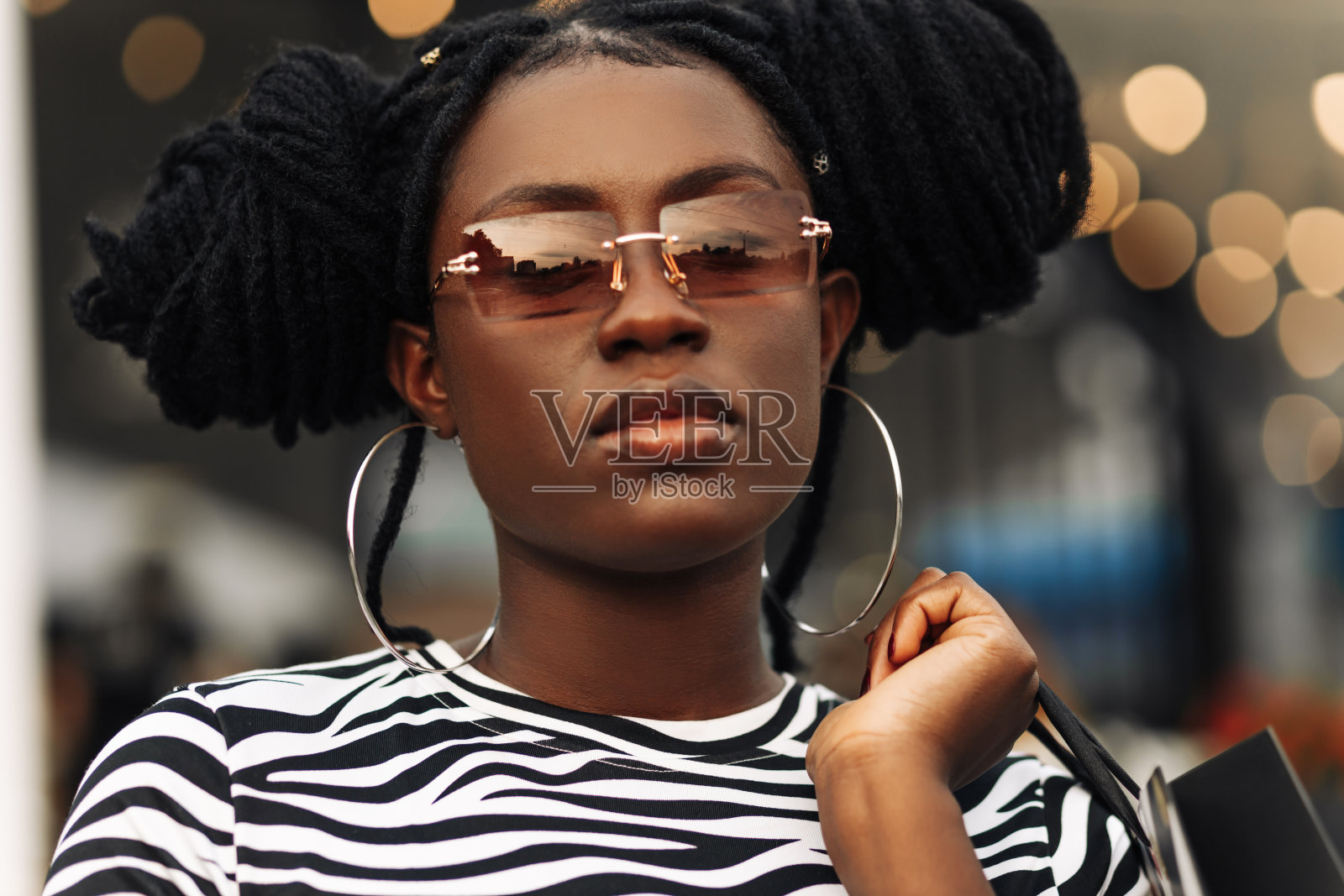 微笑的年轻黑人妇女，拿着购物袋，购物中心照片摄影图片