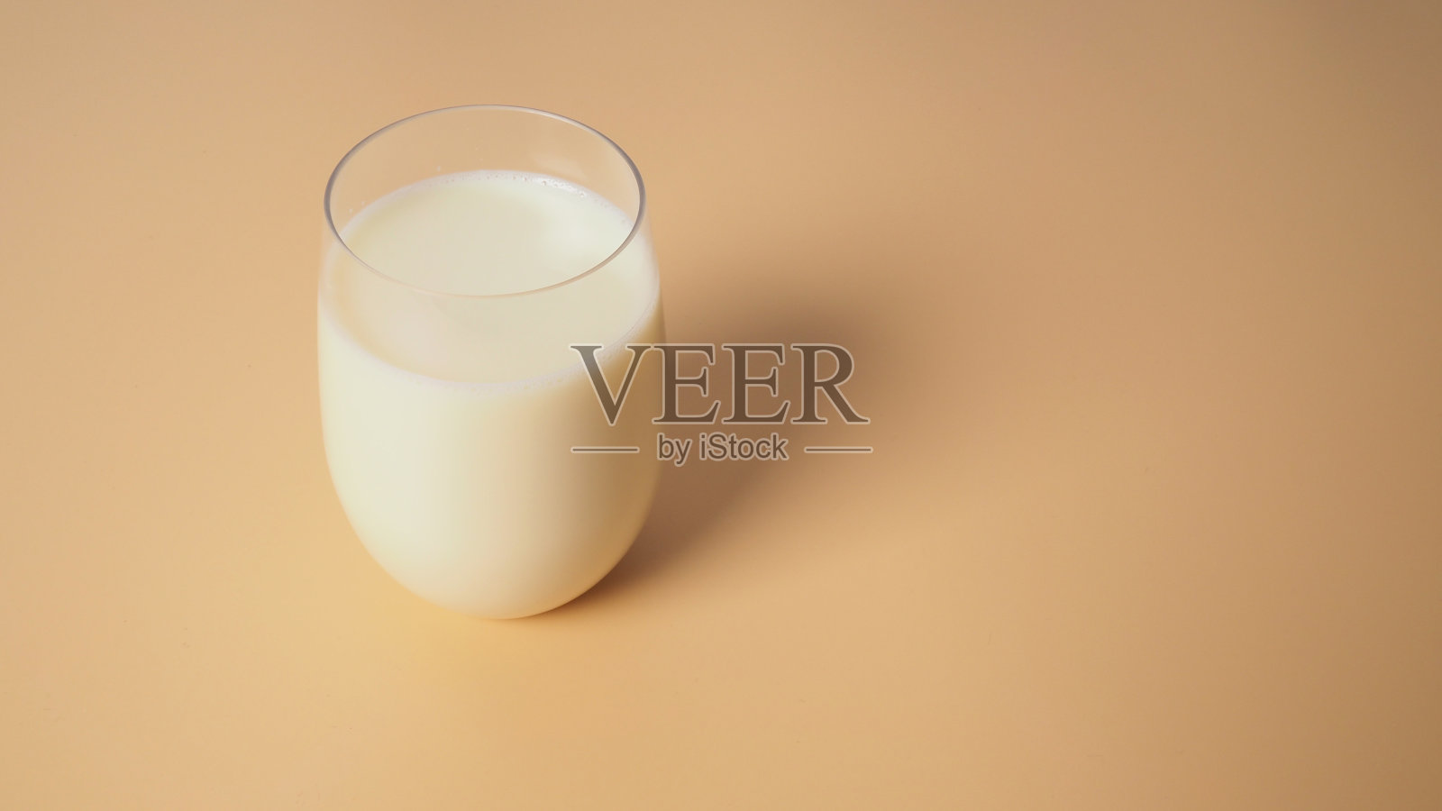 豆浆在黄色背景玻璃上。照片摄影图片