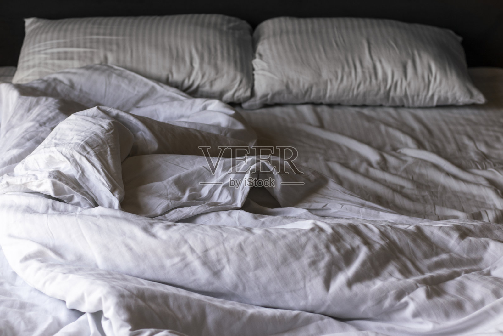 早上有白色皱褶床单的空床照片摄影图片