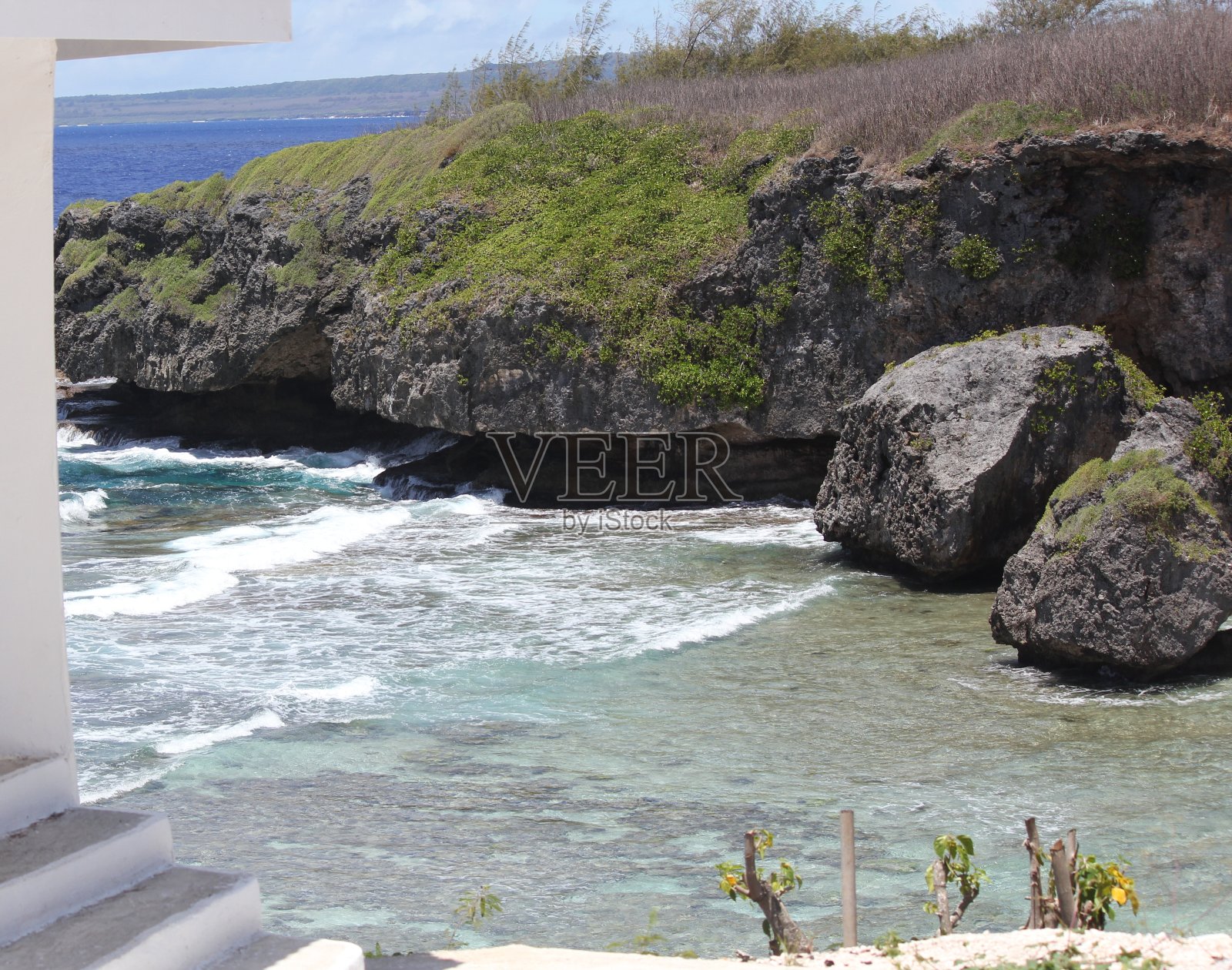 北马里亚纳群岛塞班岛上岩石嶙峋的阶梯海滩上陡峭的悬崖。照片摄影图片