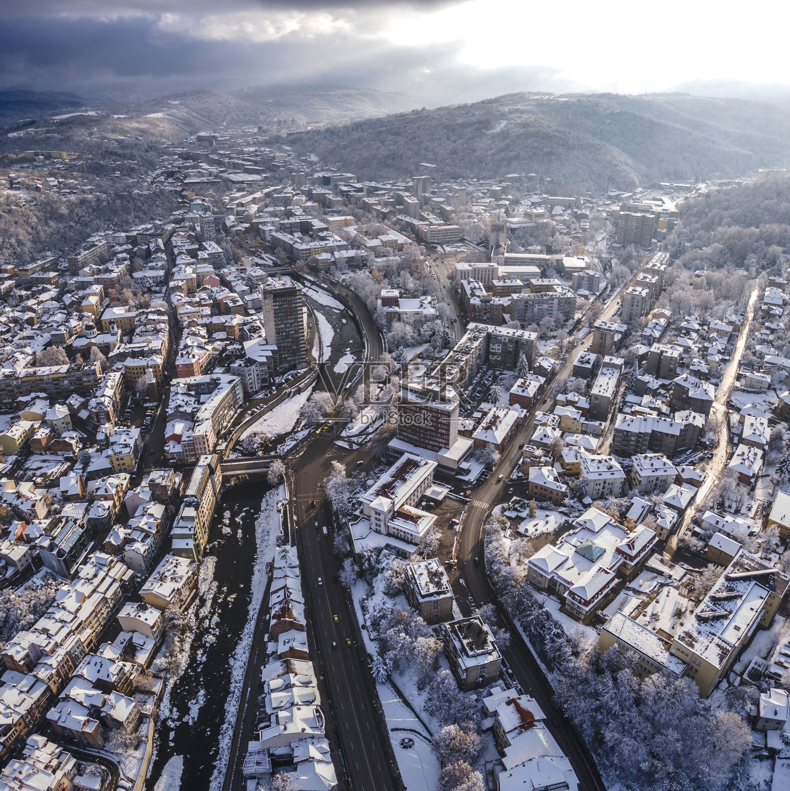 冬天的城市天线，积雪覆盖的城市在早晨的阳光。第一场雪。照片摄影图片