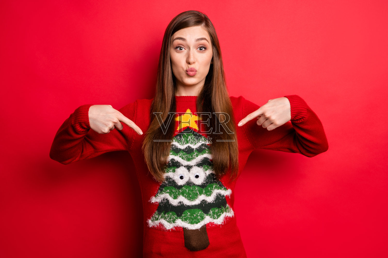乐观的千禧女士点节日毛衣孤立在红色背景的照片照片摄影图片