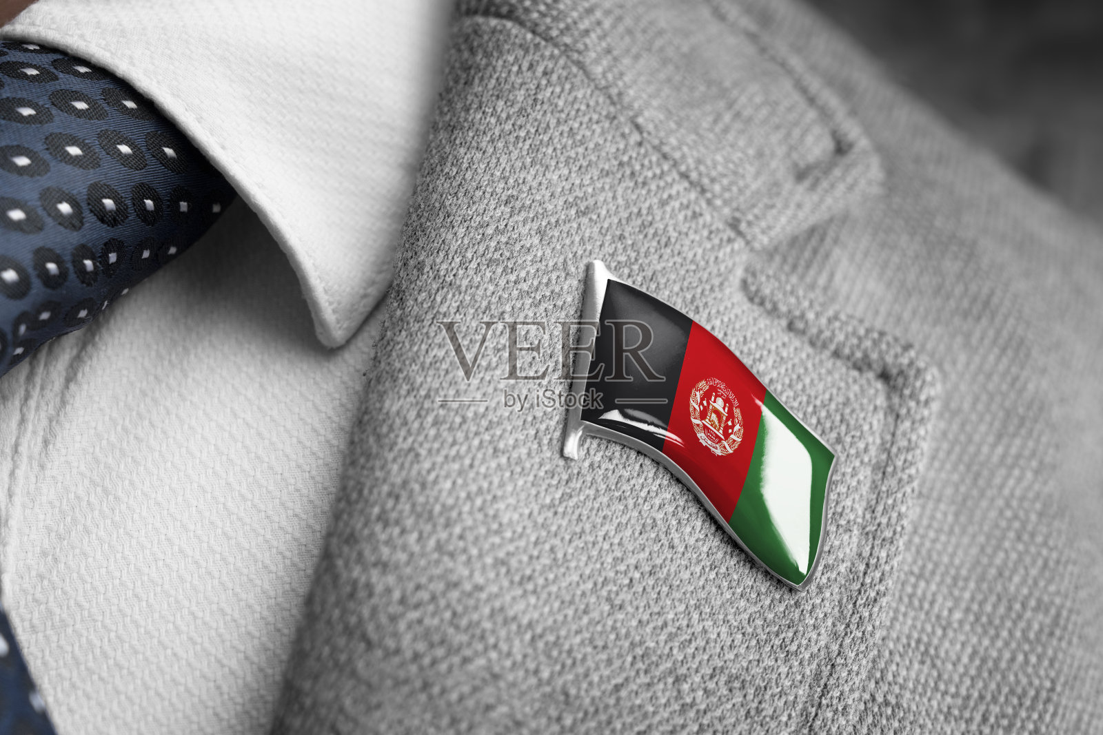 西装翻领上有印有阿富汗国旗的金属徽章照片摄影图片