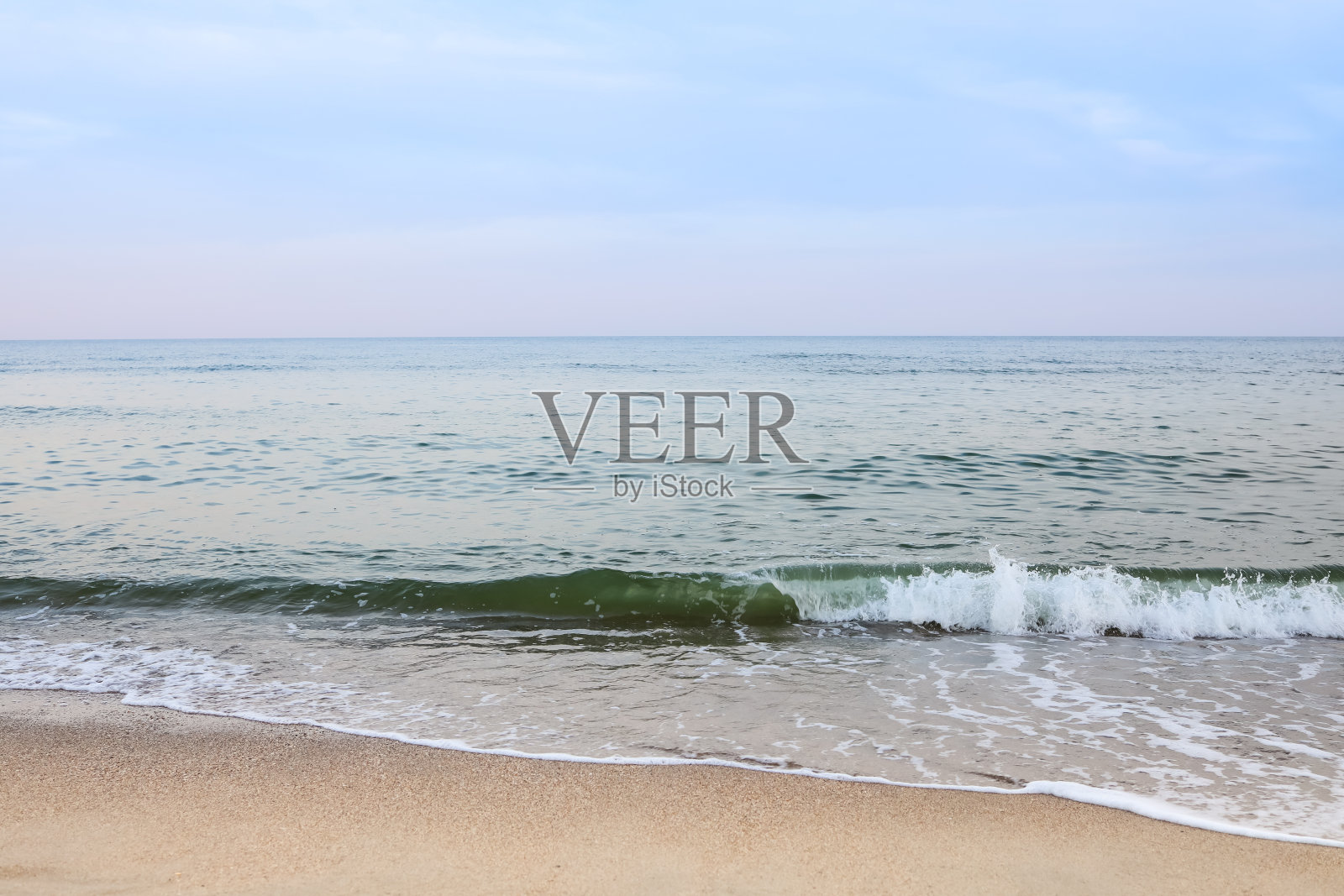 美丽的大海夏天抽象的背景。金色的沙滩，蓝色的海洋，云彩和日落在后面。照片摄影图片