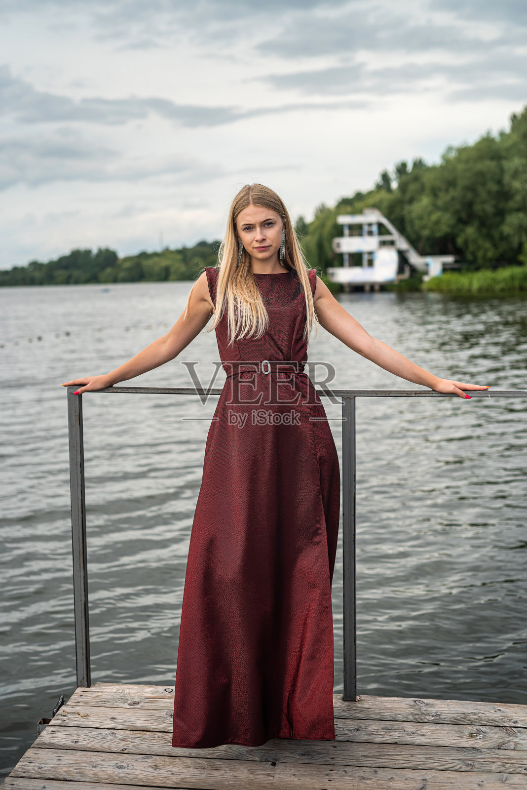 美丽的女人穿着深红色的长裙站在大自然中照片摄影图片