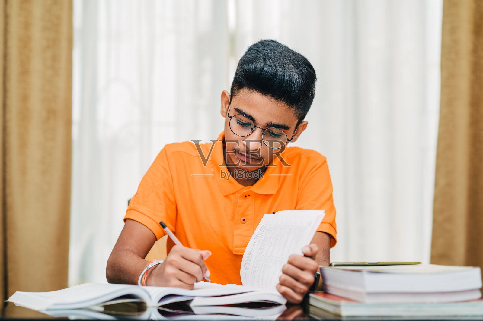 小男孩准备考试，在家学习。照片摄影图片