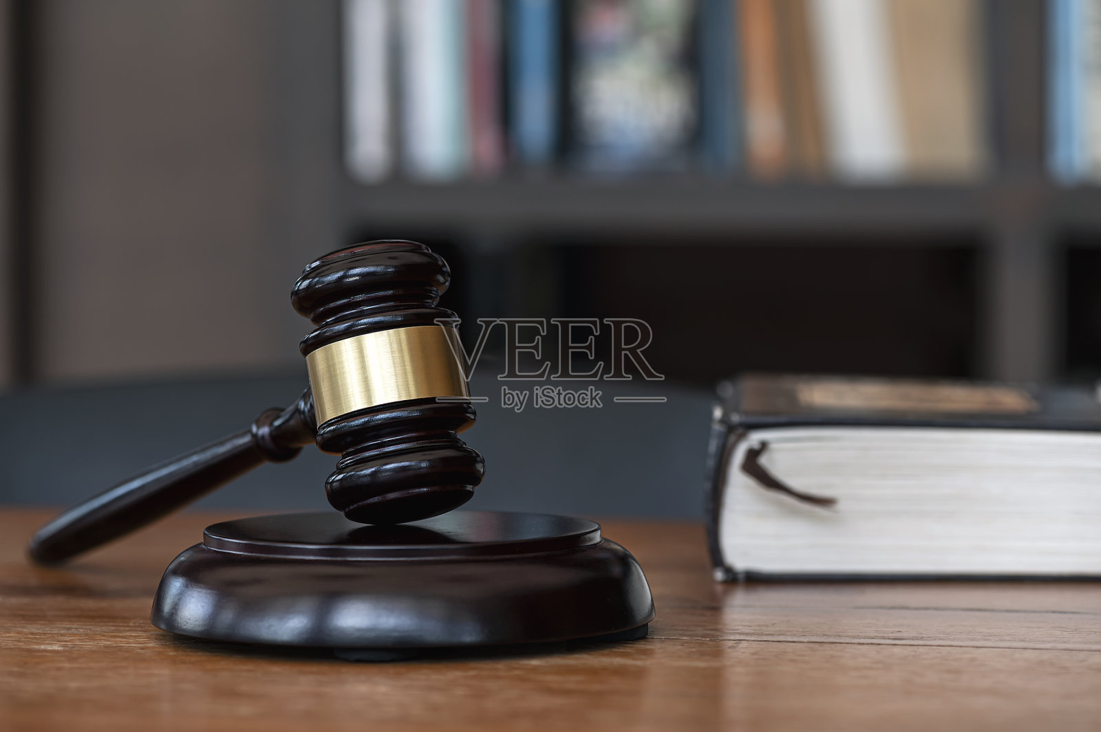 黑暗房间木桌上的法官 gavel，模糊背景，法律概念照片摄影图片