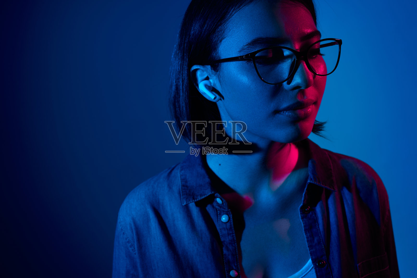 年轻的黑发女人闭着眼睛听音乐照片摄影图片