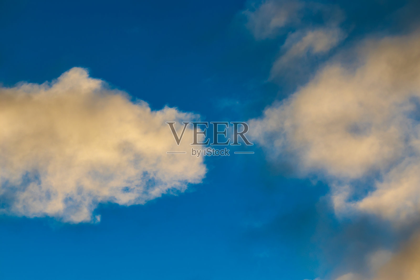 黄昏时，蓝色的天空下漂浮着白色的积云。照片摄影图片