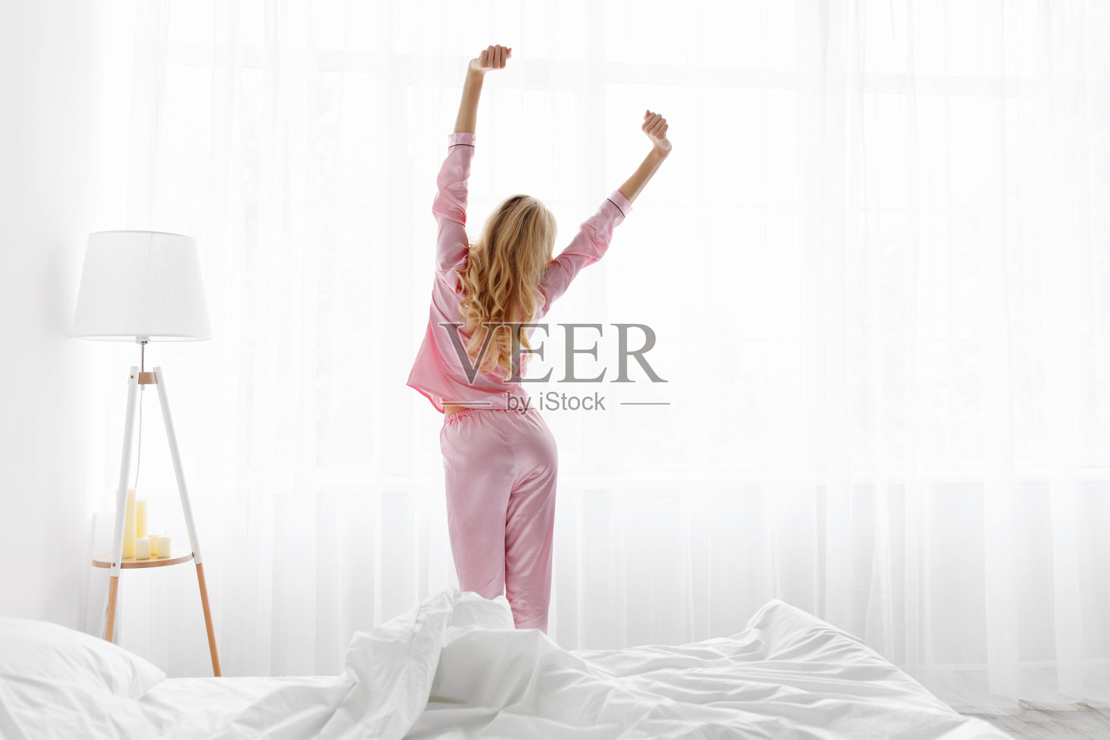 女人醒来，站在窗前，会日出照片摄影图片