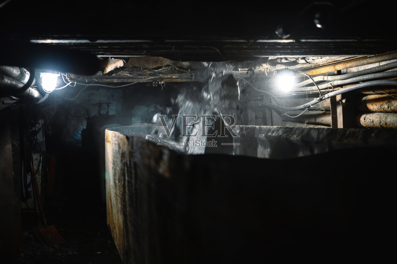 把矿石和石头装在矿车里。矿石从上面落入矿车照片摄影图片