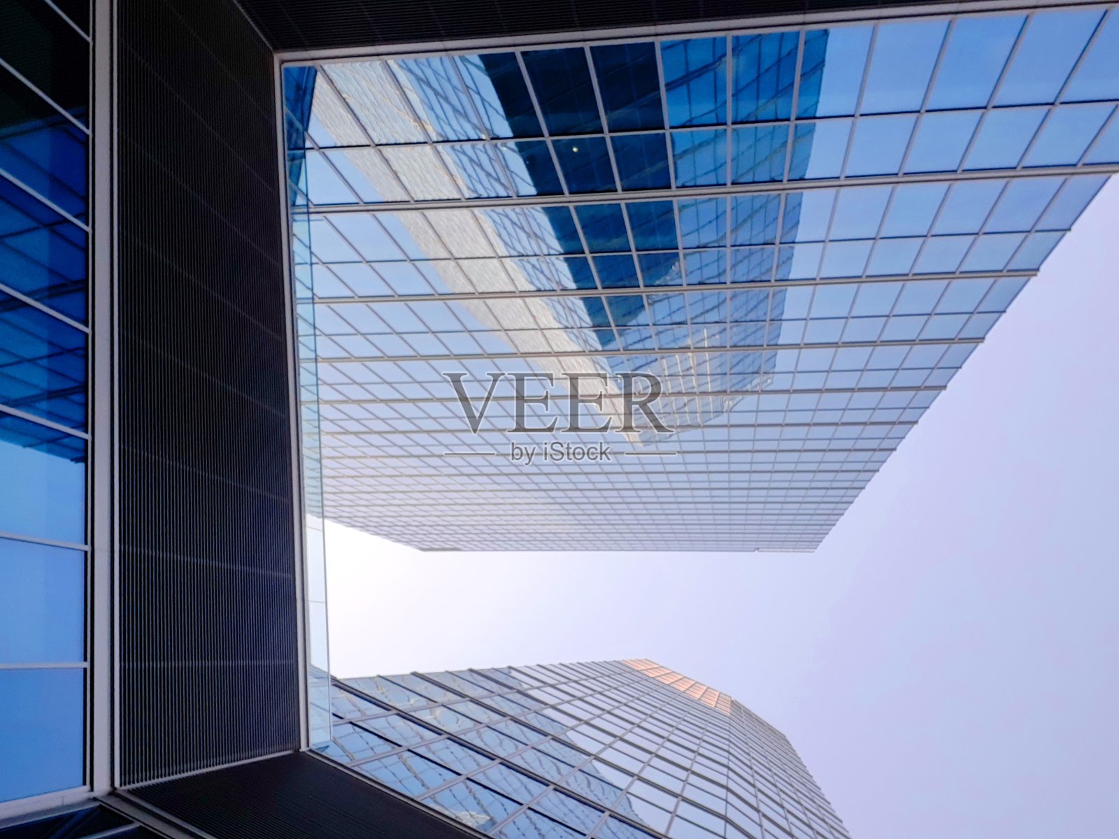 商业中心的玻璃摩天大楼在蓝天的映衬下从下面拍摄照片摄影图片